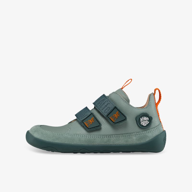 Bequemer Schuh mit zwei Klettverschlüssen, flexibler Sohle und modernem Design in Grün mit orangen Details