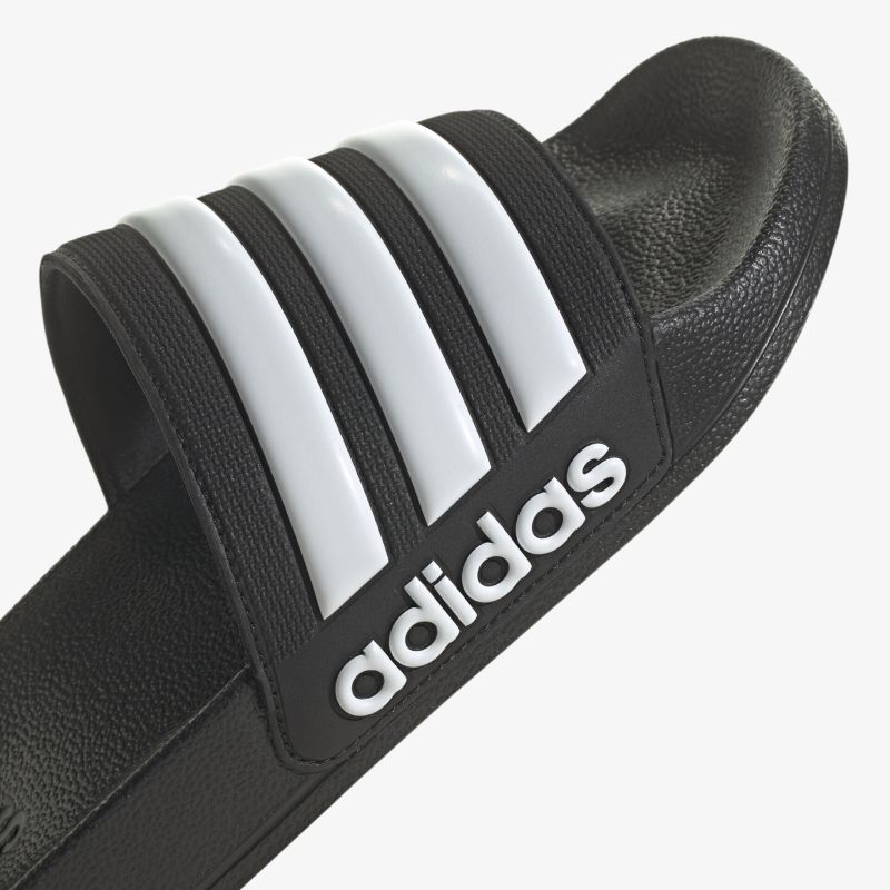 Adidas Schlappen in Schwarz mit ikonischen weißen Streifen, ideal für Komfort und Stil.