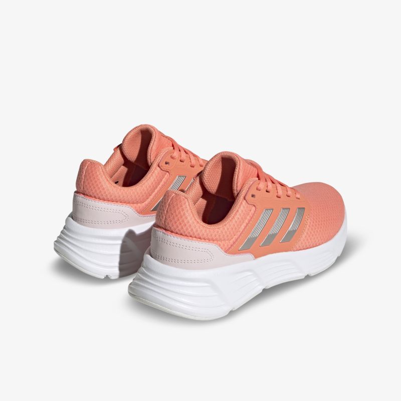 Bequeme, stylische Sportschuhe in Koralle mit weißer Sohle und Markendetails, ideal für Sport und Freizeit.
