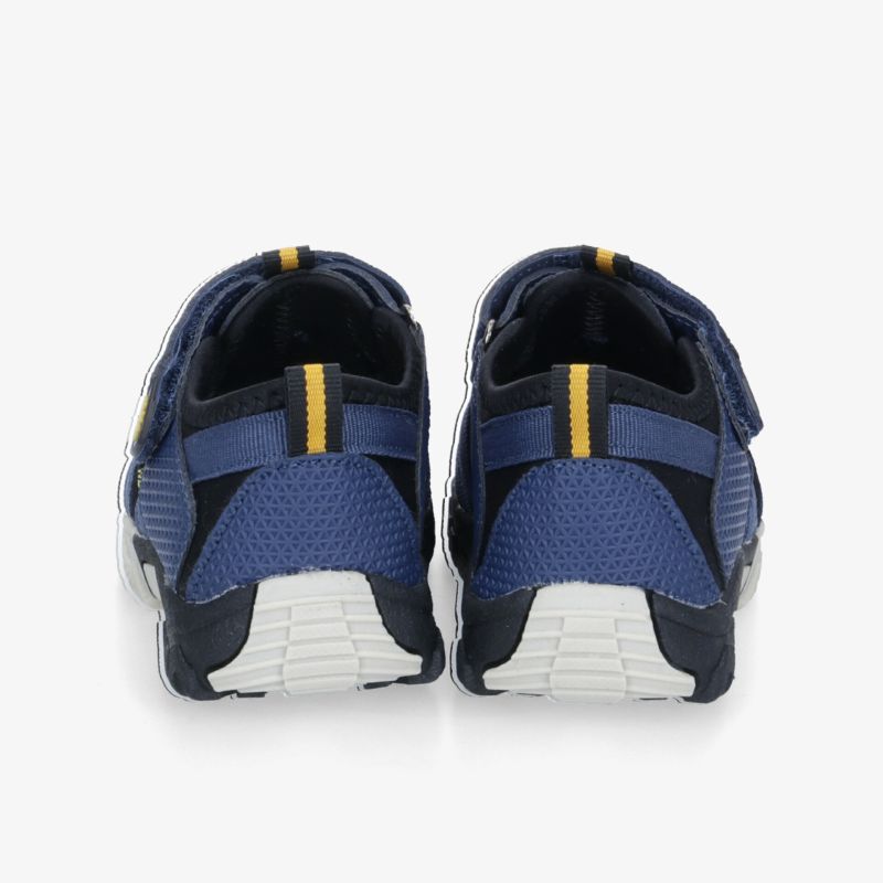 Rückansicht von blauen Sportschuhen mit gelben Details und weißer Sohle. Perfekt für vielseitige Aktivitäten geeignet.