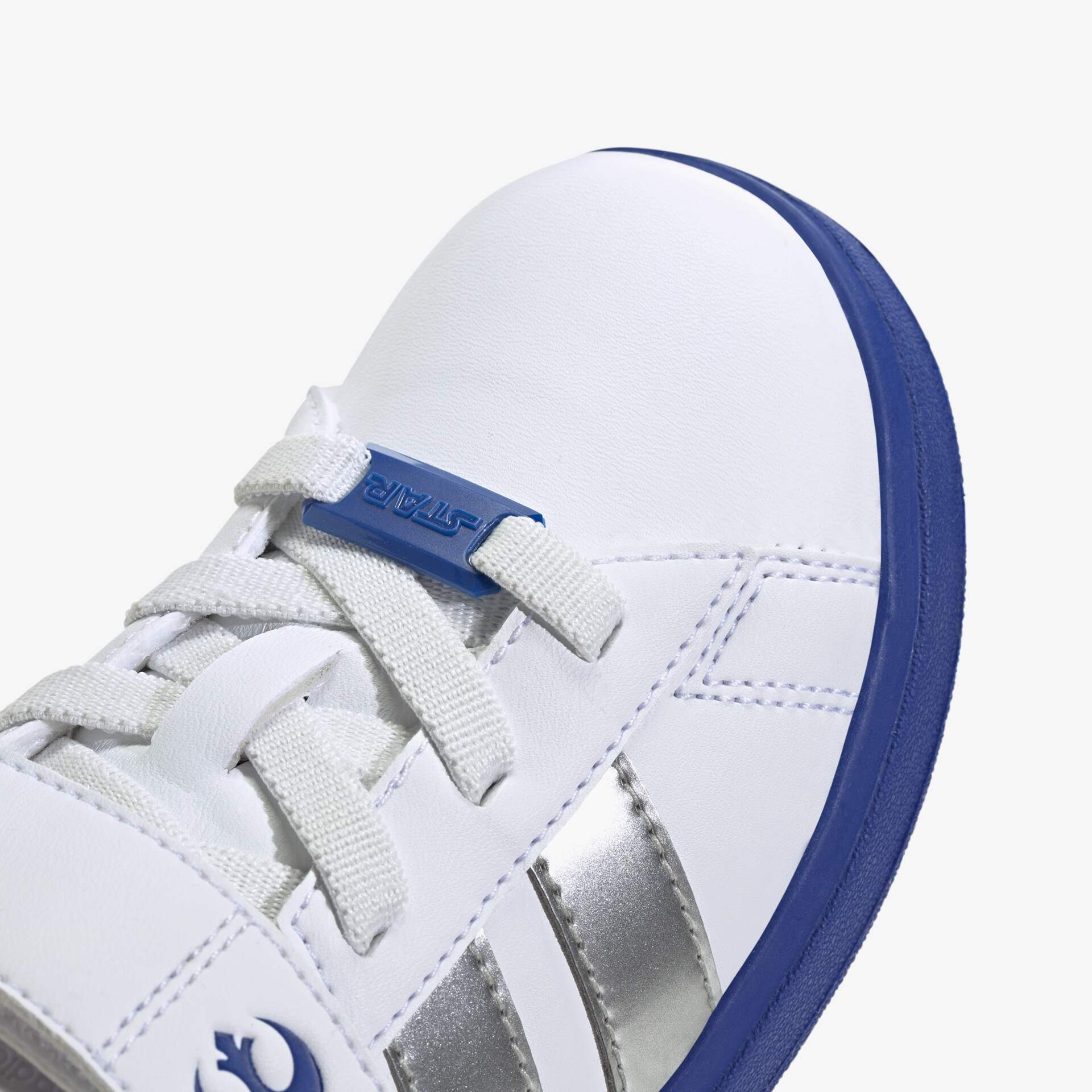 Detailansicht eines weißen Sportschuhs mit blauem Sohlenrand und stabiler Schnürung, hochwertige Verarbeitung