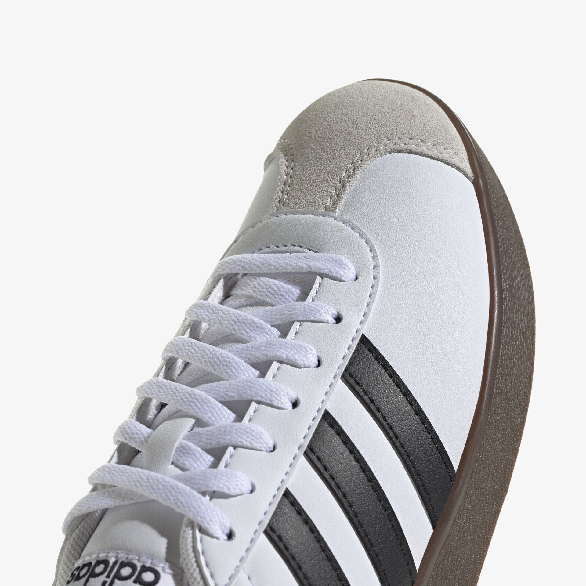 Weißer Sportschuh mit schwarzen Streifen und stabiler Schnürung, detailreicher Nahaufnahme