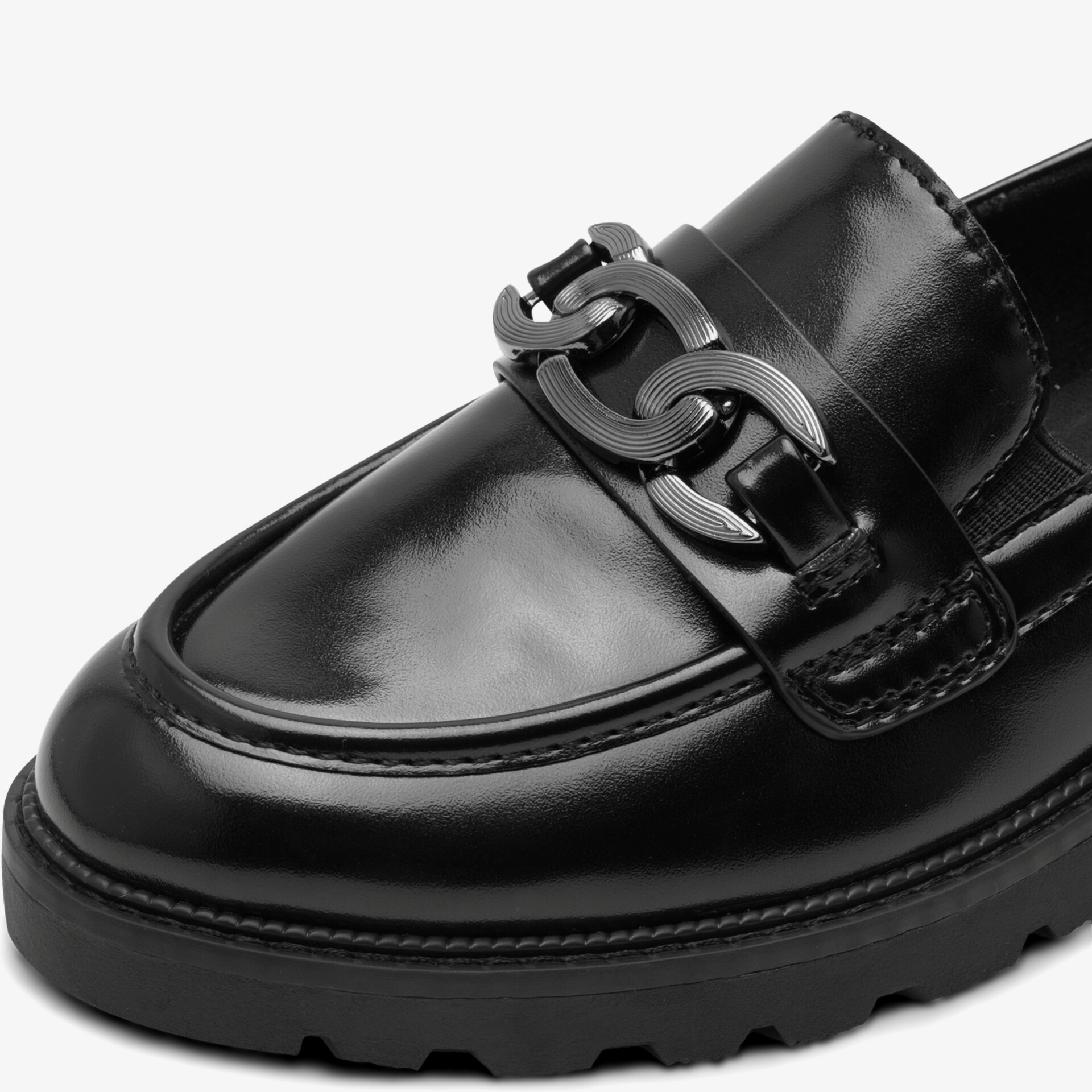 Schwarzer Lederslipper mit eleganter Metallverzierung und feiner Nahtarbeit in Detailansicht