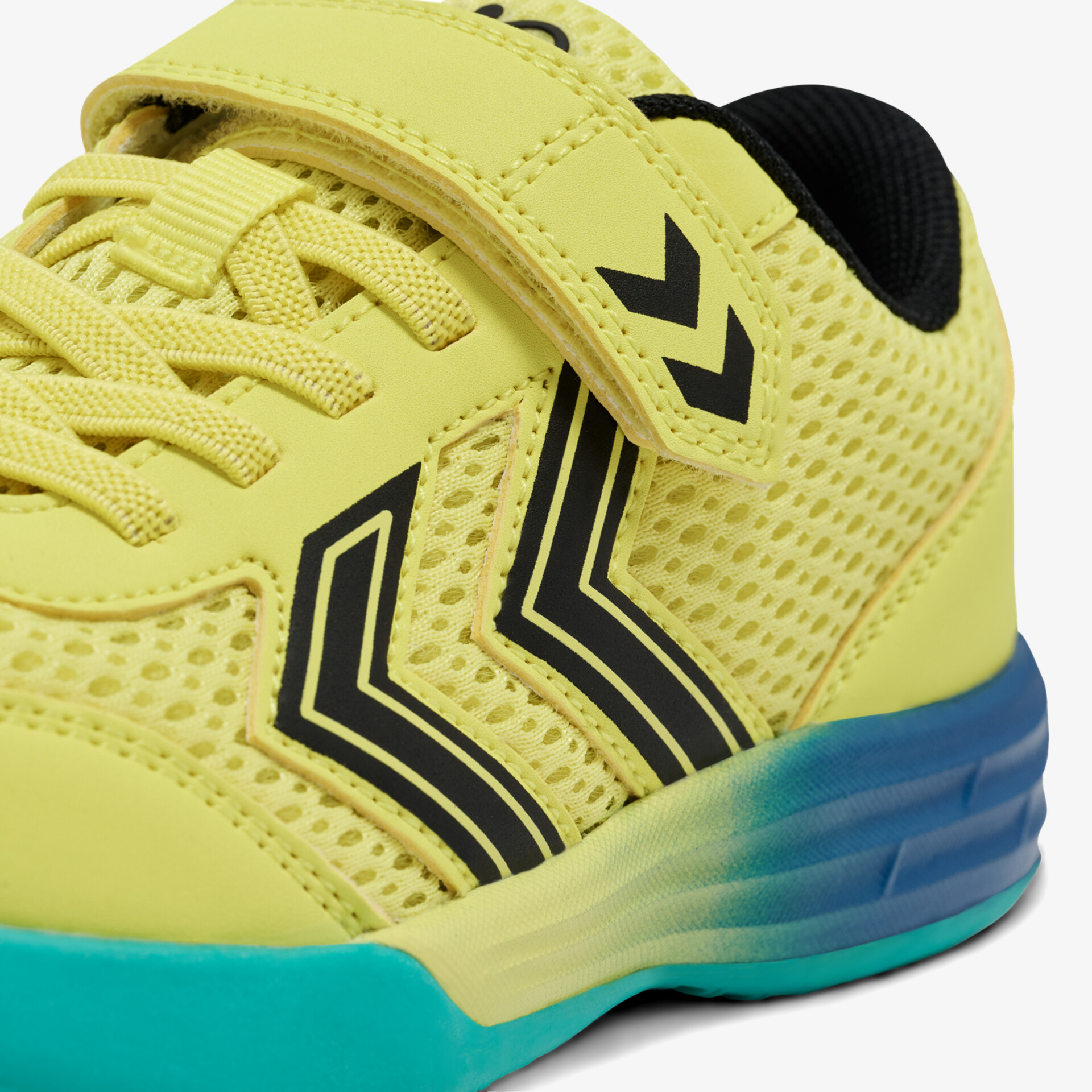 Sportlicher gelber Schuh mit Klettverschluss und rutschfester blauer Sohle. Ideale Atmungsaktivität und Tragekomfort.