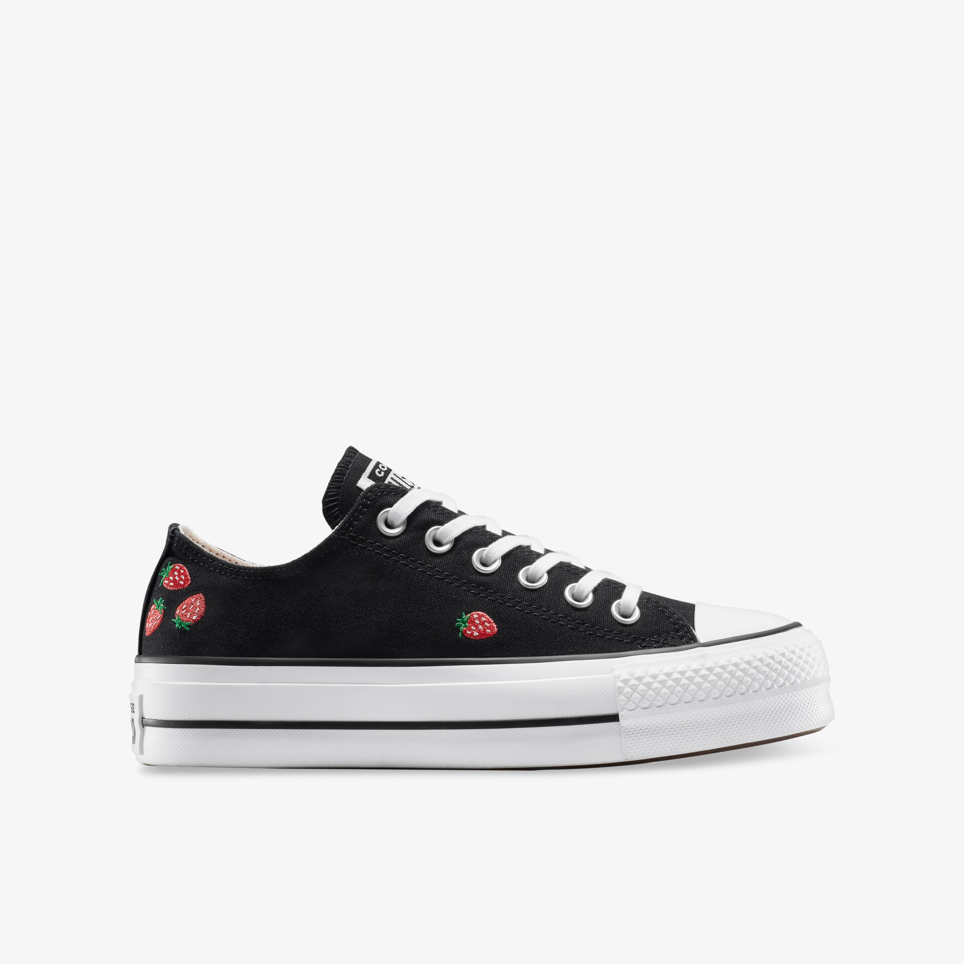 Seitliche Ansicht eines schwarzen Sneakers mit weißen Schnürsenkeln und roten Stickereien, flache weiße Sohle