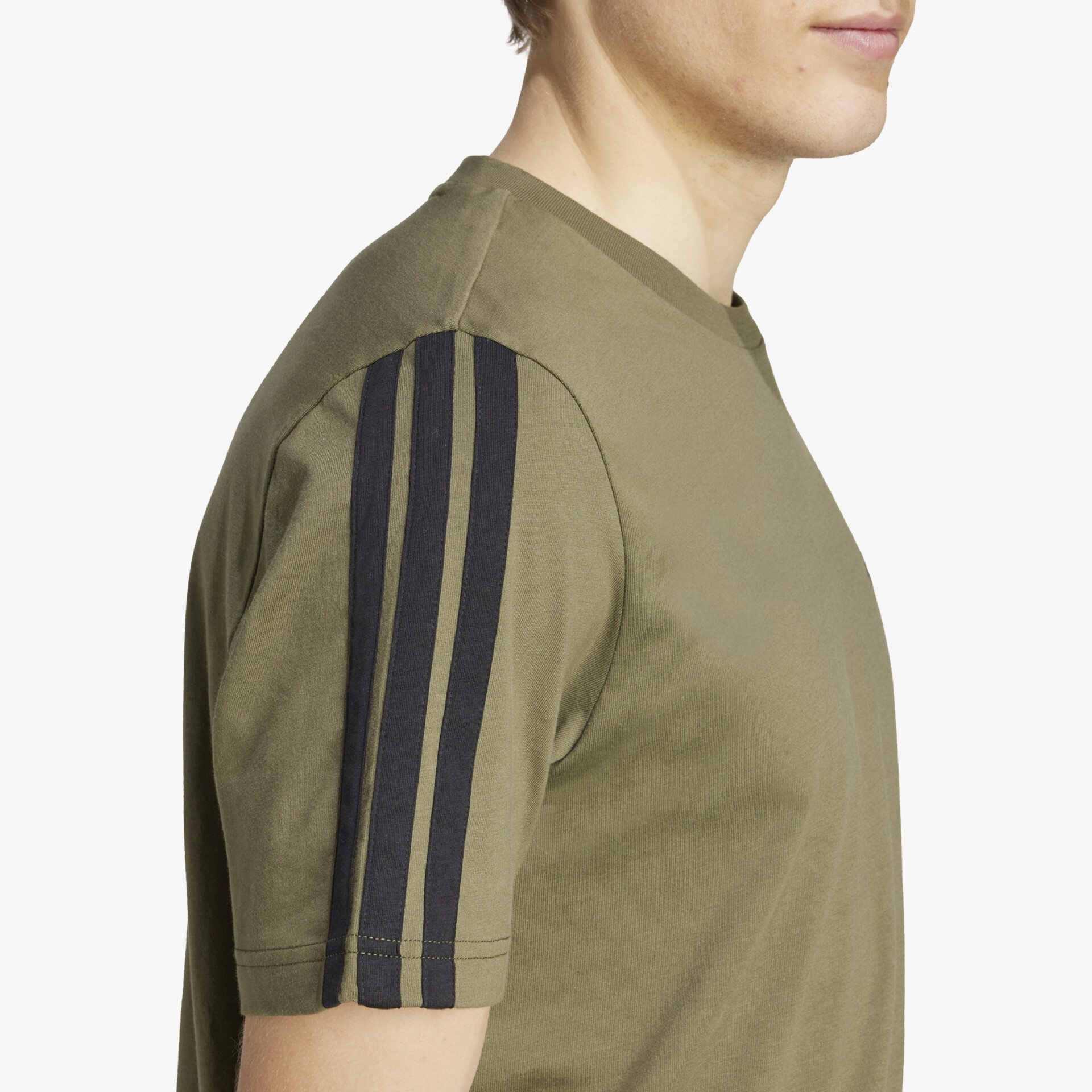 Detailaufnahme eines olivegrünen Shirts mit schwarzen Dreistreifen auf dem Ärmel und hochwertiger Stoffqualität