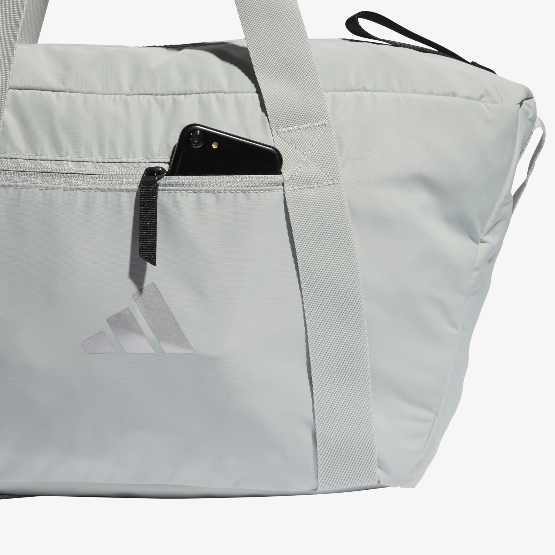 Geräumige weiße Sporttasche mit Reißverschluss und Smartphone-Tasche an der Seite.