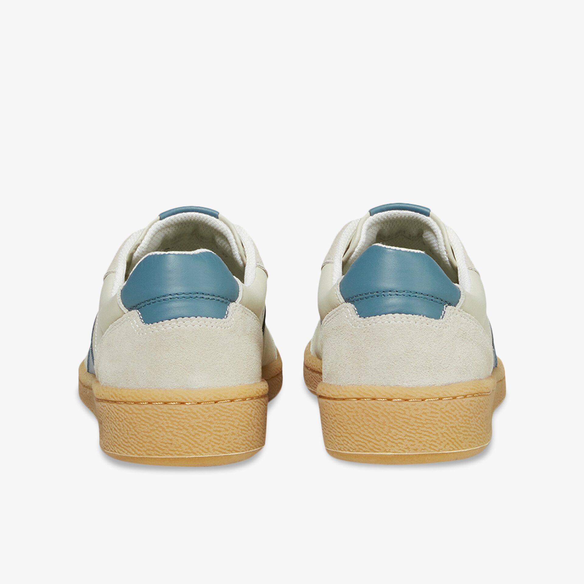 Rückansicht von weißen Schuhen mit blauem Fersenbereich und robuster hellbrauner Gummisohle