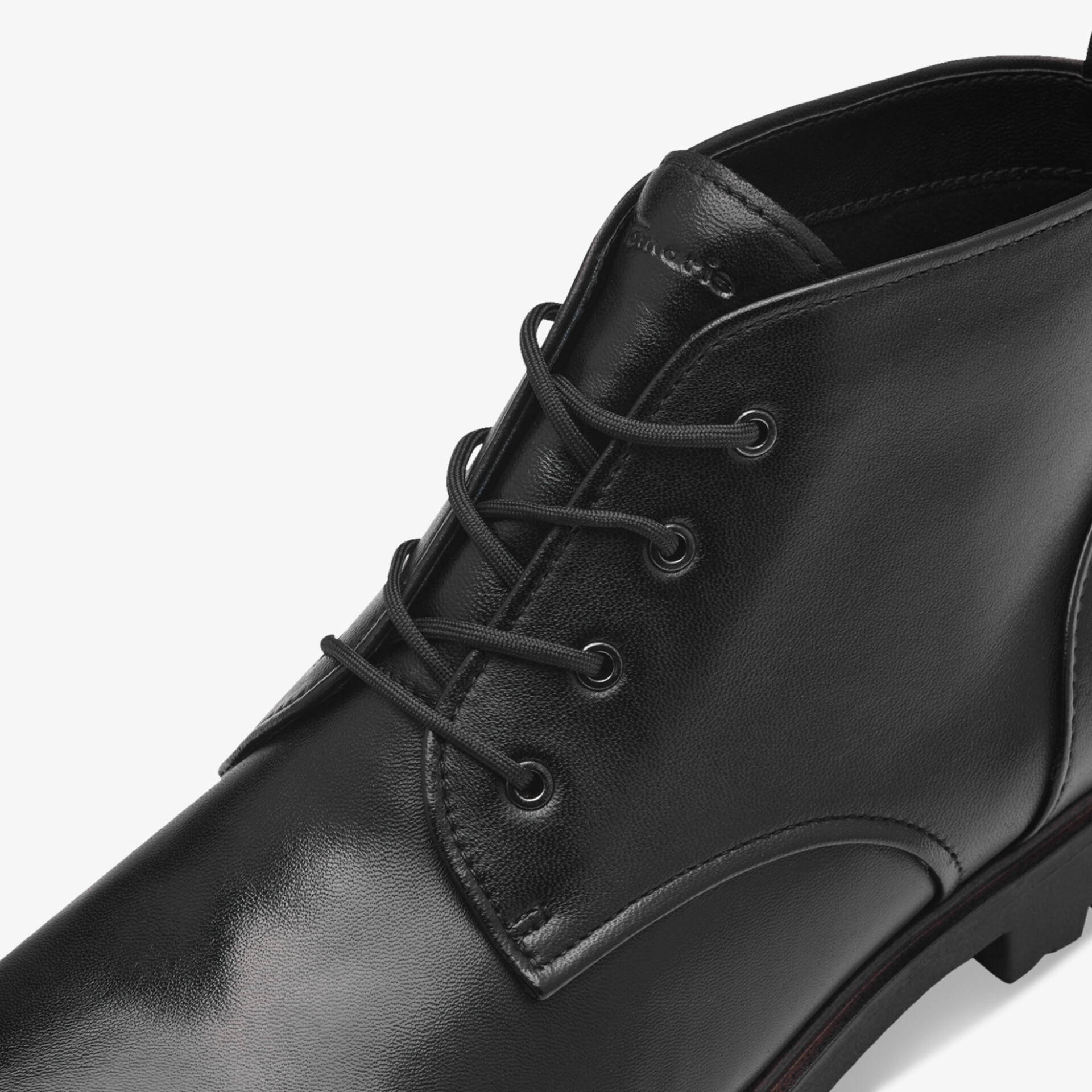 Schwarzer Lederstiefel mit robuster Schnürung und feiner Nahtarbeit in Nahaufnahme, hochwertiges Material sichtbar