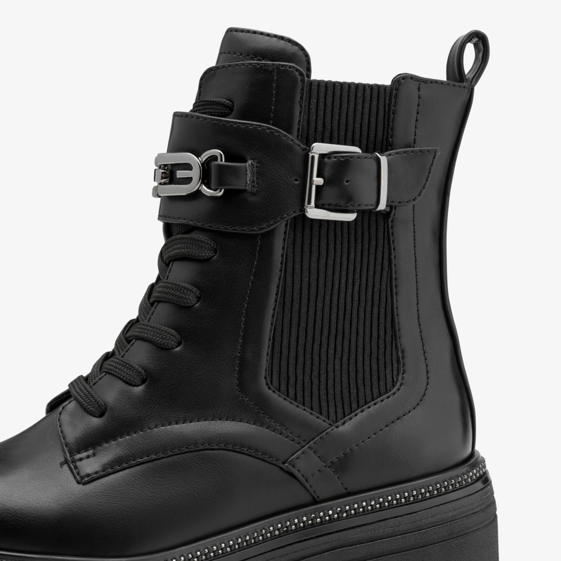 Moderner schwarzer Stiefel mit Schnürung, elastischem Einsatz und dekorativer Schnalle auf robuster Plateausohle