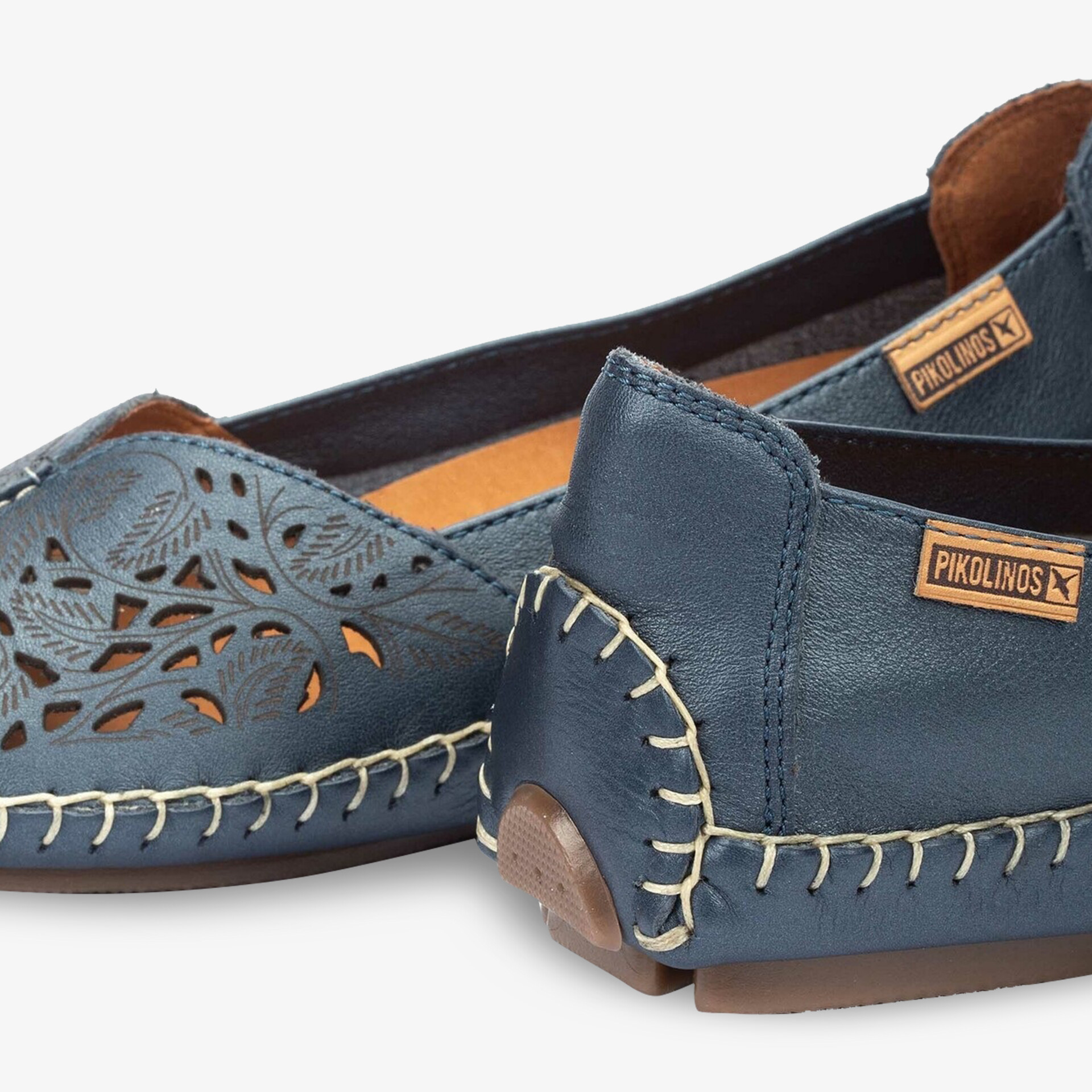 Detailaufnahme von hochwertigen blauen Lederschuhen mit flexiblen Nähten und dekorativen Ausschnitten