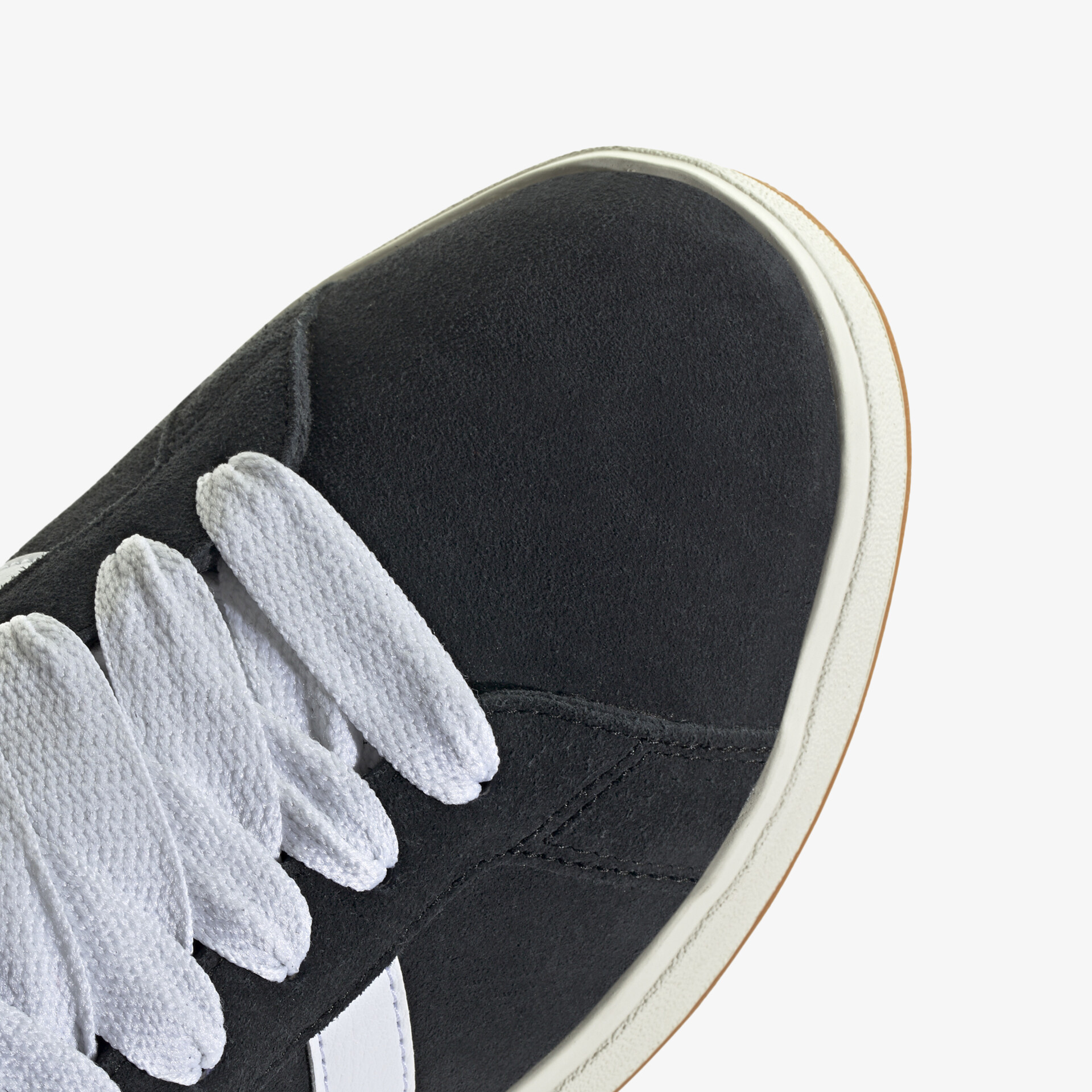 Detailaufnahme schwarzer Schuh mit weißen Schnürsenkeln, robustes Material und präzise Verarbeitung