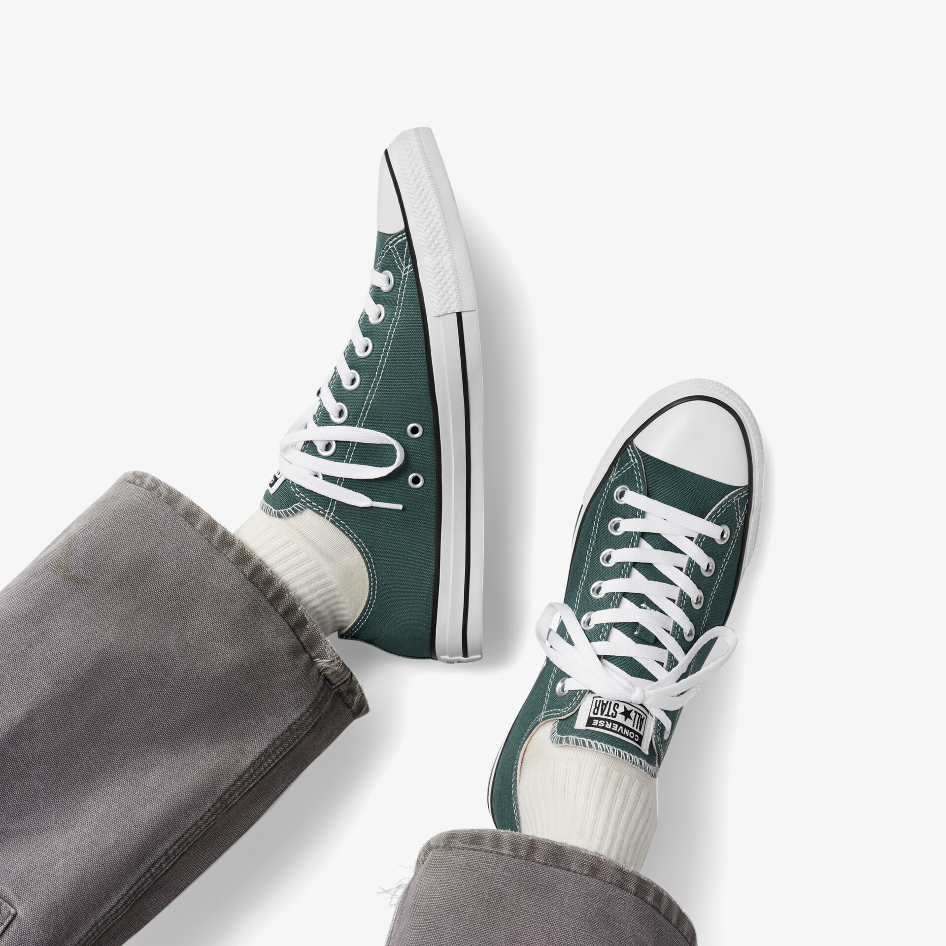 Sportlicher grüner Sneaker mit weißer Profilsohle und Schnürsenkeln, komfortabel und robust, getragen am Fuß
