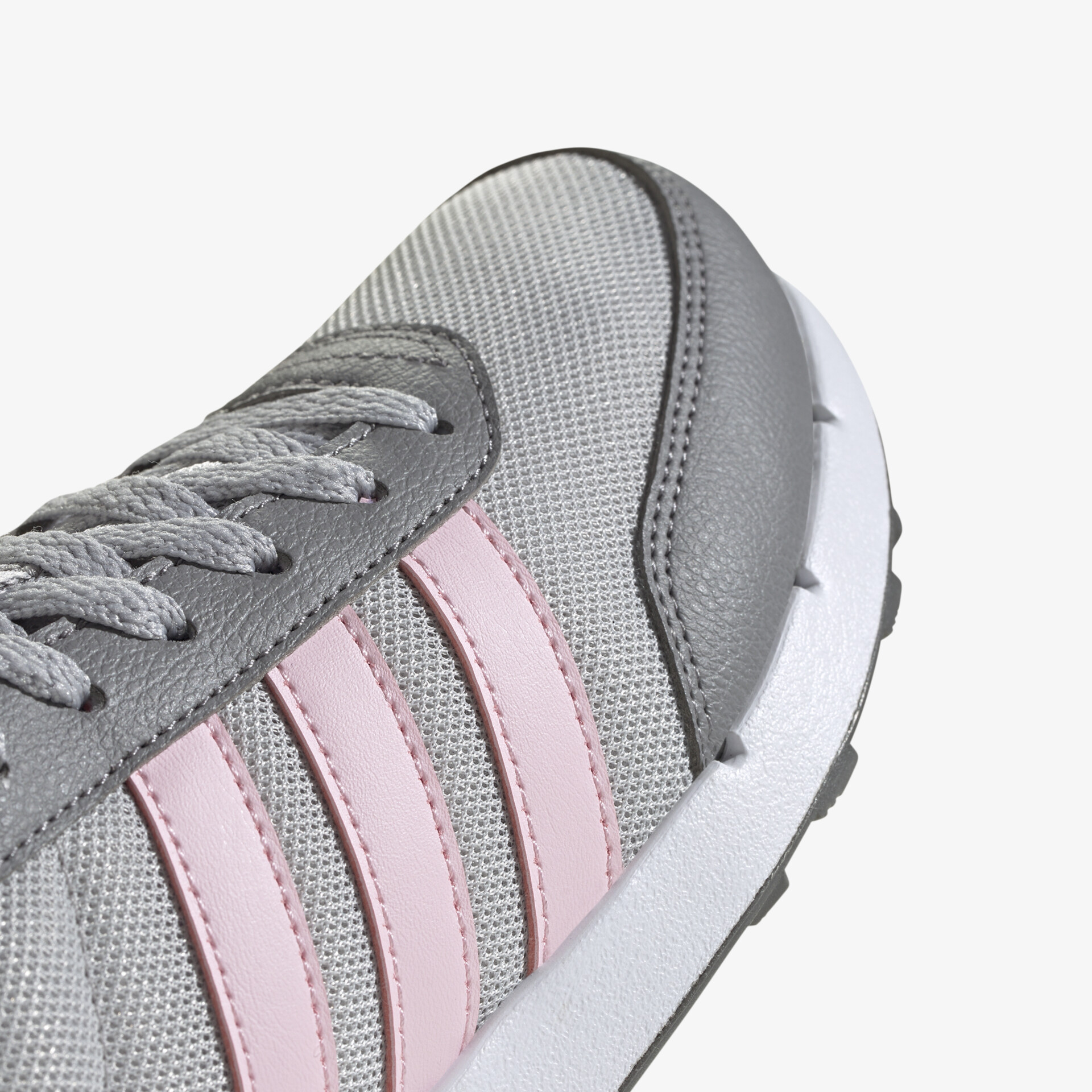 Detaillierte Nahaufnahme eines grauen Sportschuhs mit rosa Streifen und hochwertiger Mesh-Oberfläche