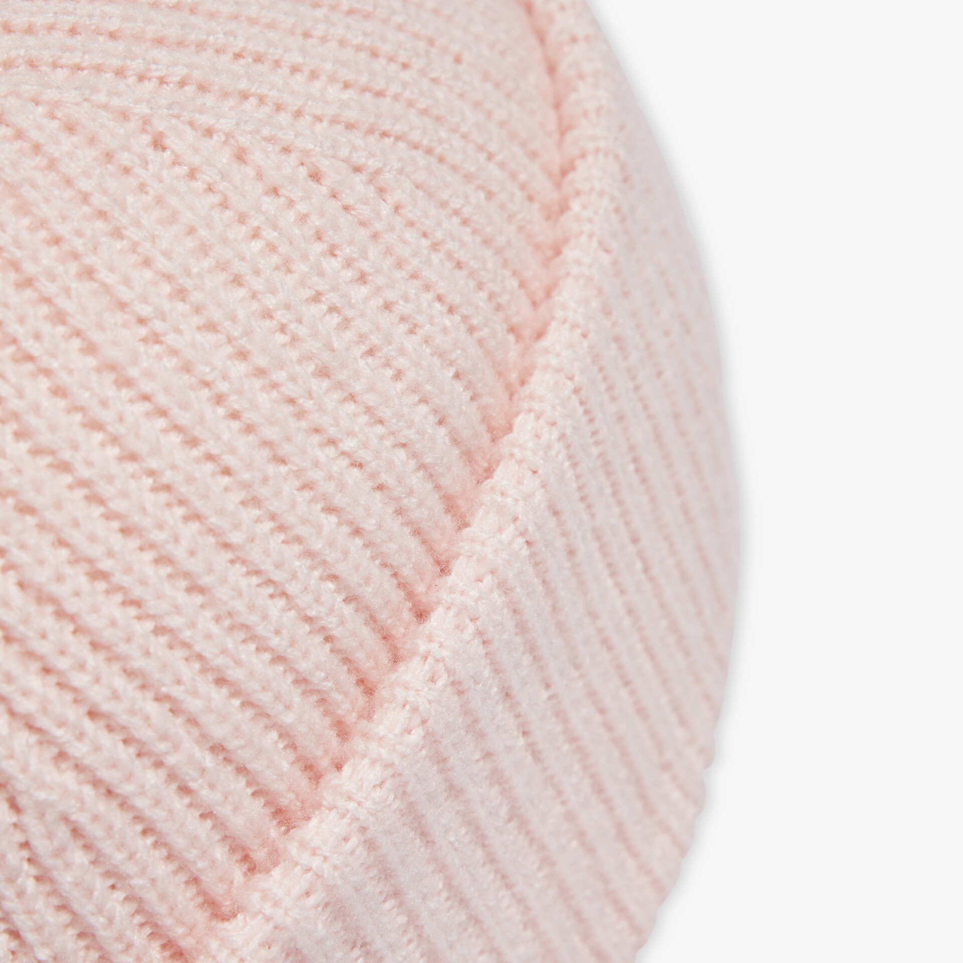 Detailaufnahme von weichem, fein gestricktem Stoff in zartem Pastellton mit klarer strukturierter Oberfläche