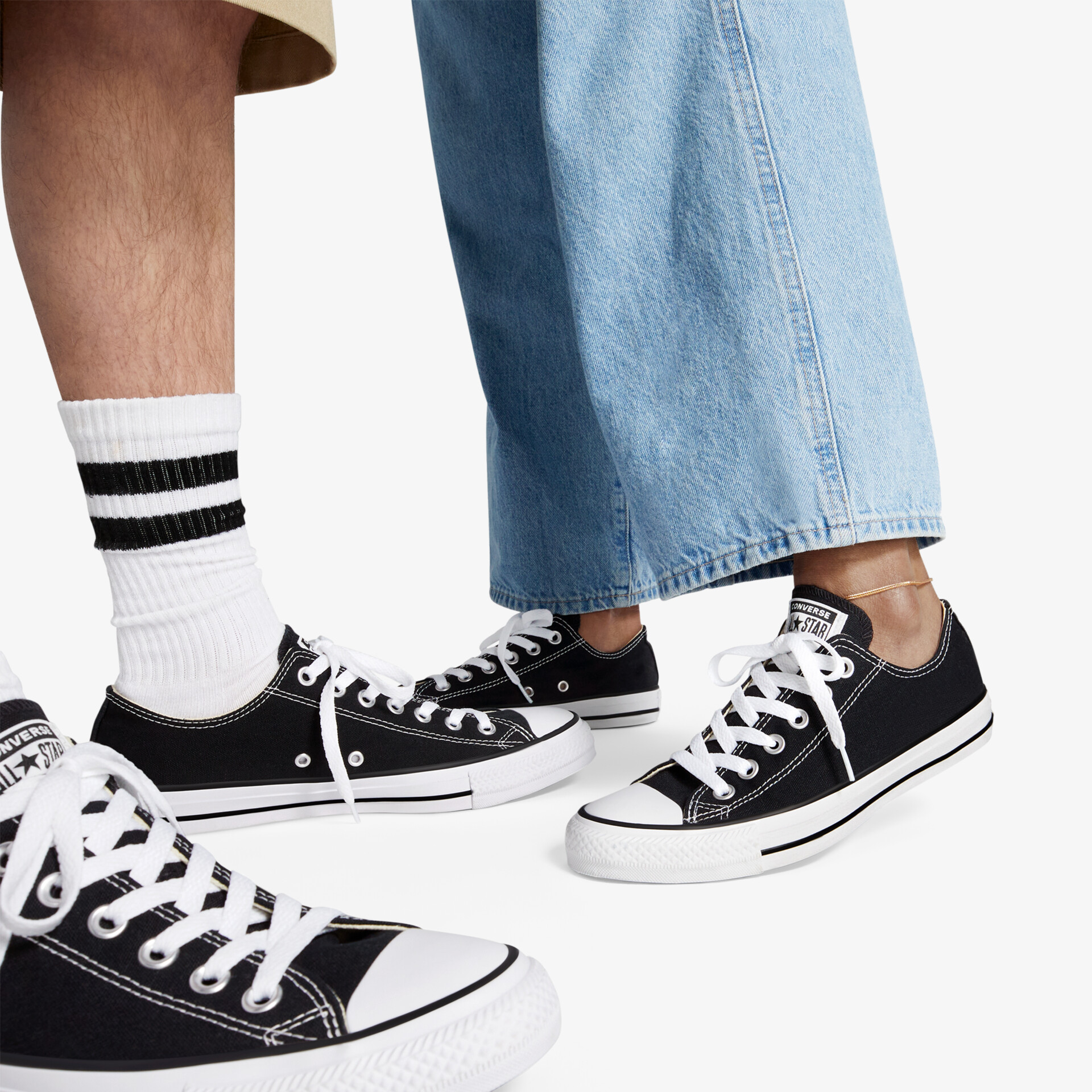Schwarze Sneaker mit weißer Sohle und Schnürung, bequem getragen an den Füßen, lässiger Look
