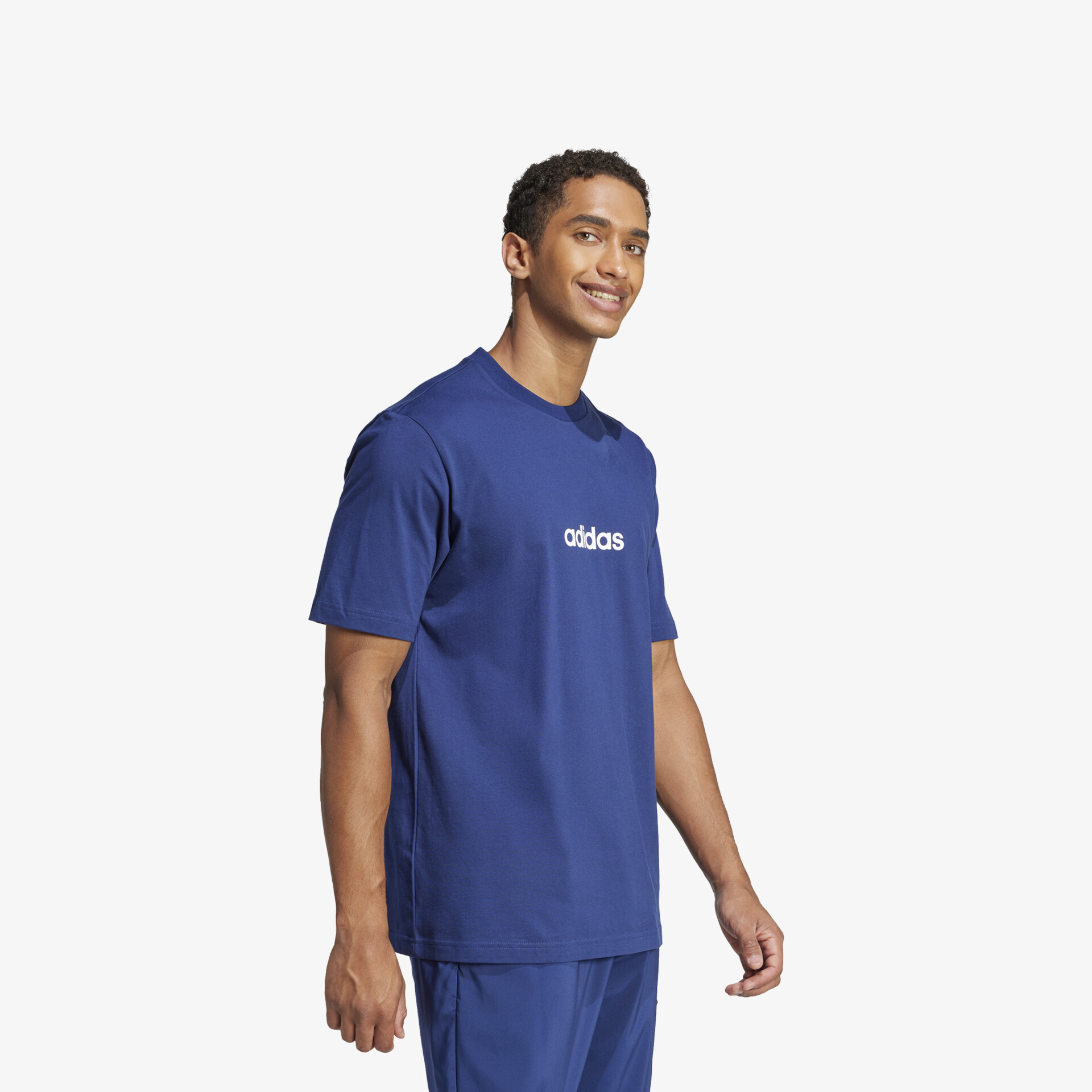 Modell trägt bequemes blaues T-Shirt seitlich stehend mit schlichtem sportlichem Design