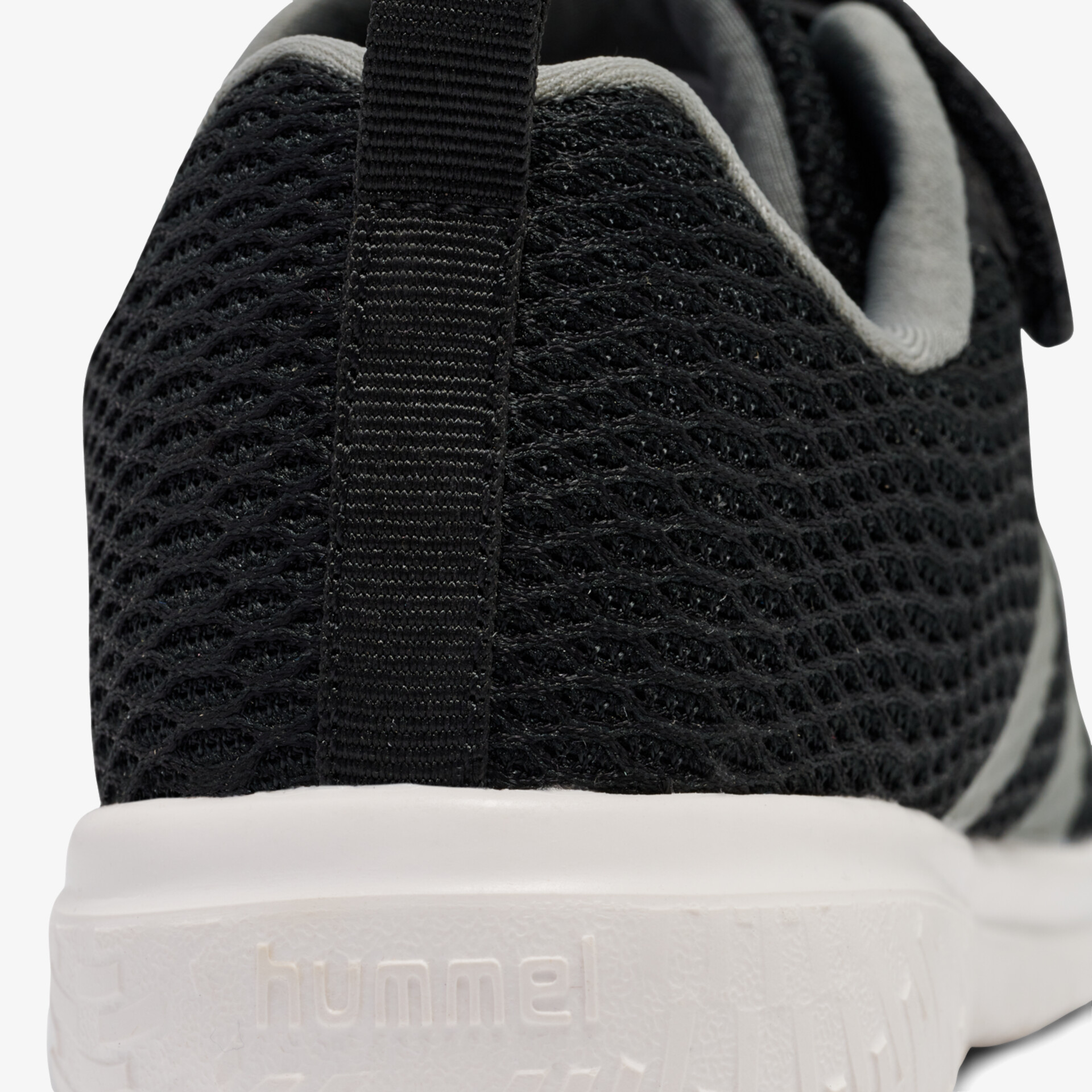 Detailaufnahme der Ferse eines atmungsaktiven, leichten Sportschuhs mit rutschfester weißer Sohle und schwarzem Obermaterial