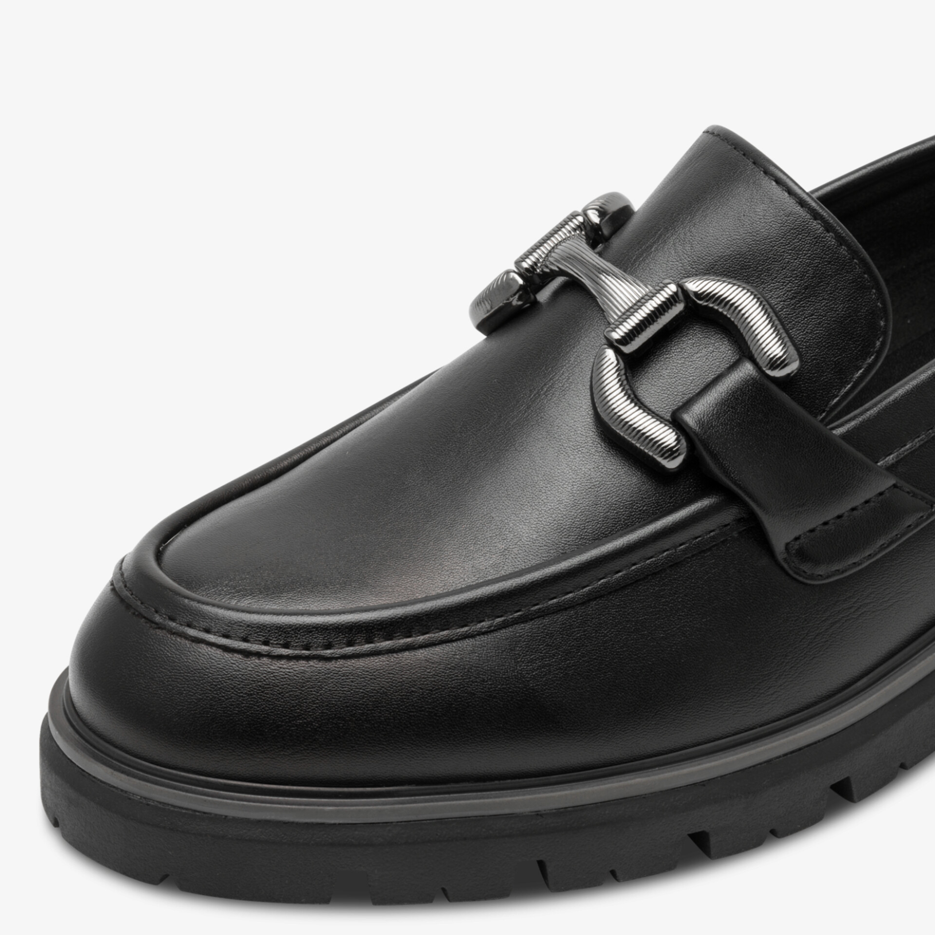 Eleganter schwarzer Lederslipper mit Riegel, feiner Naht und komfortabler Gummisohle nah aufgenommen