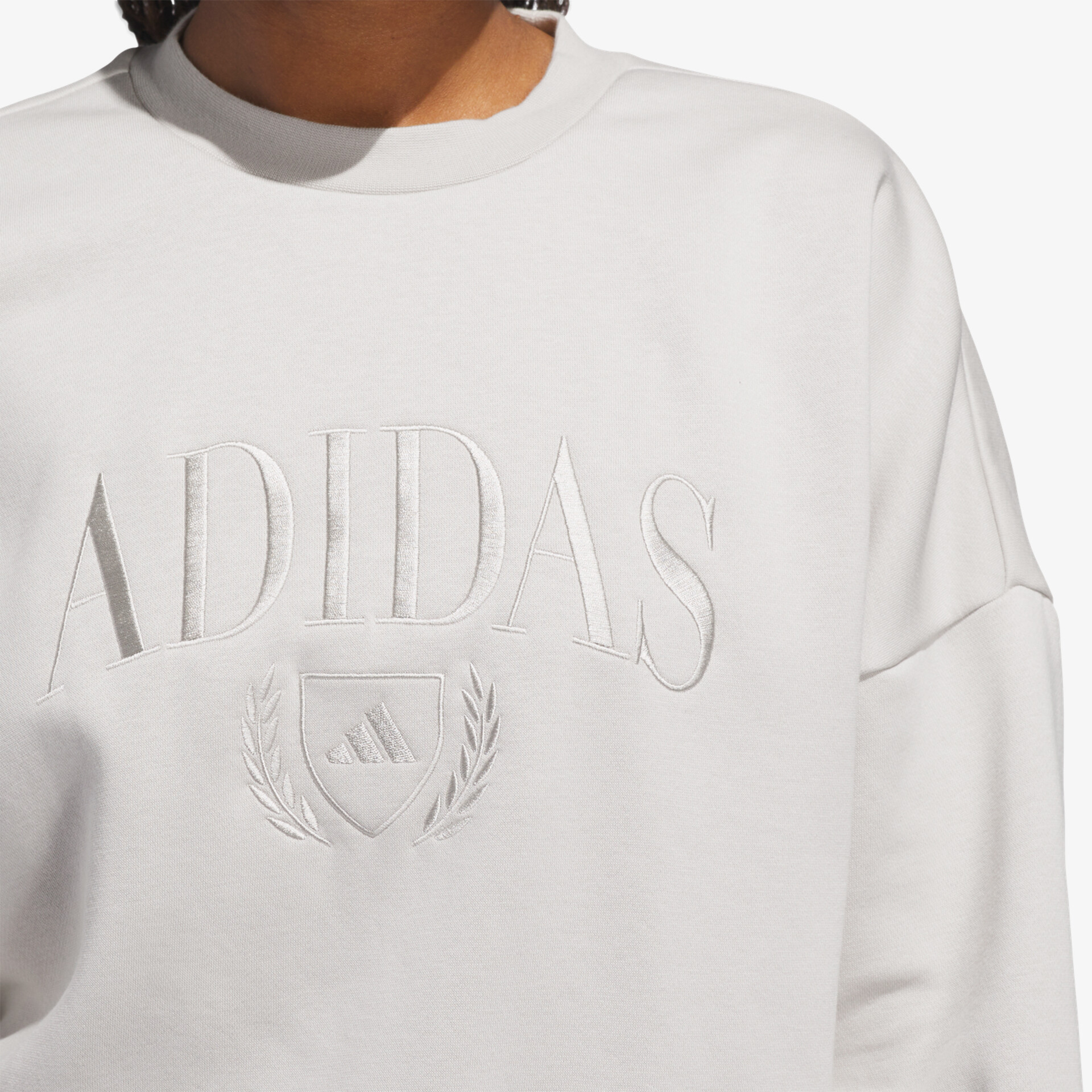 Weißes Sweatshirt mit dezentem Adidas-Logo und hochwertigem, weichem Material in Nahaufnahme