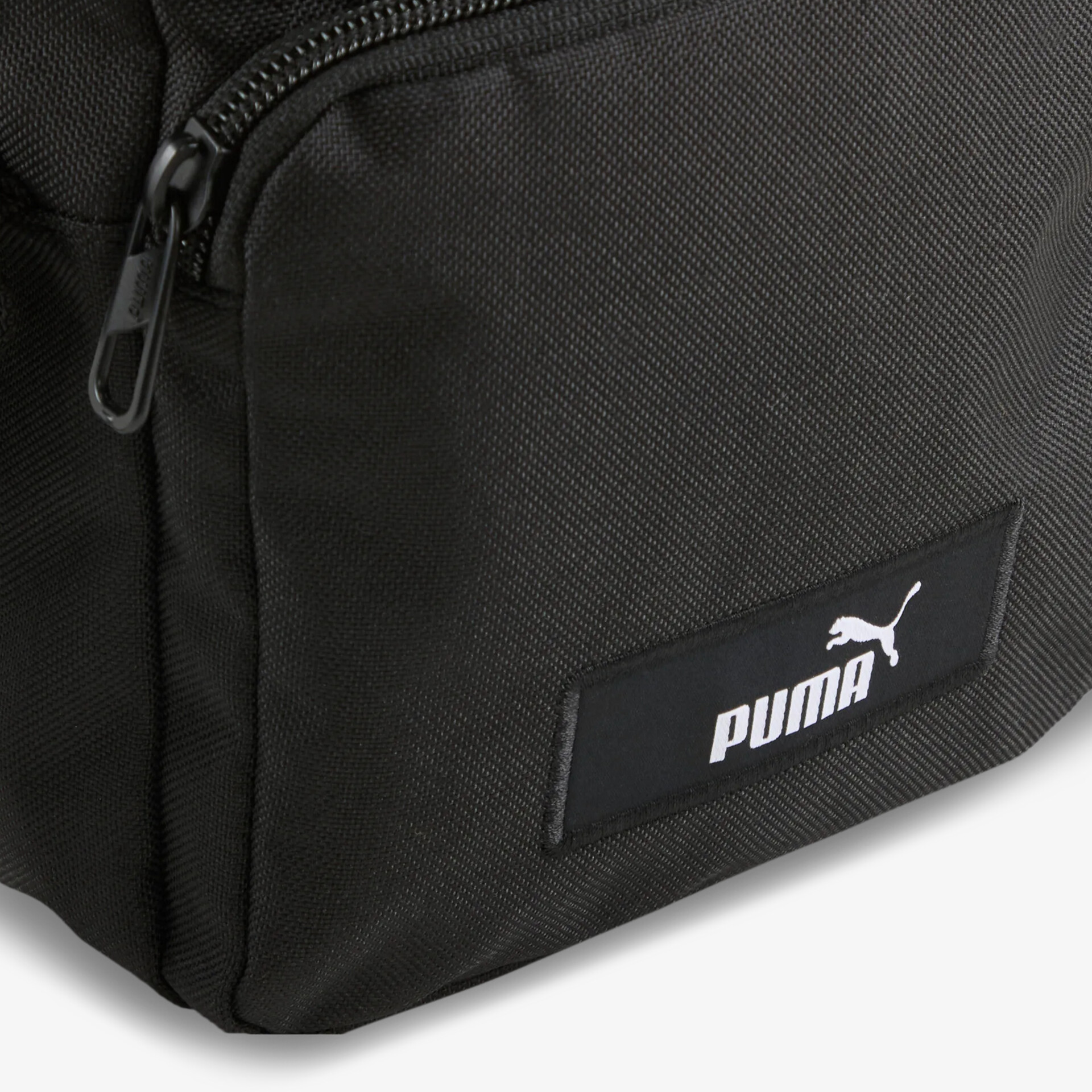 Detailaufnahme des schwarzen Puma Rucksacks mit gut erkennbarem Reißverschluss und klar sichtbarem Logo