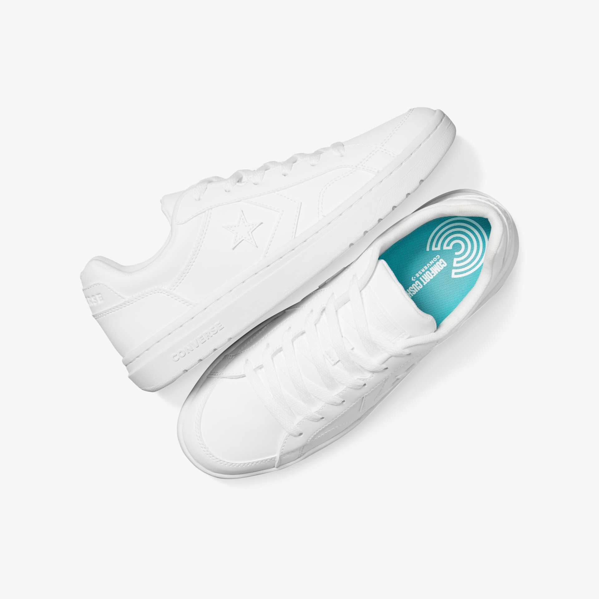Weißes Sneaker-Paar mit flexiblem, leichtem Design und klassischen Schnürsenkeln, liegend von oben fotografiert