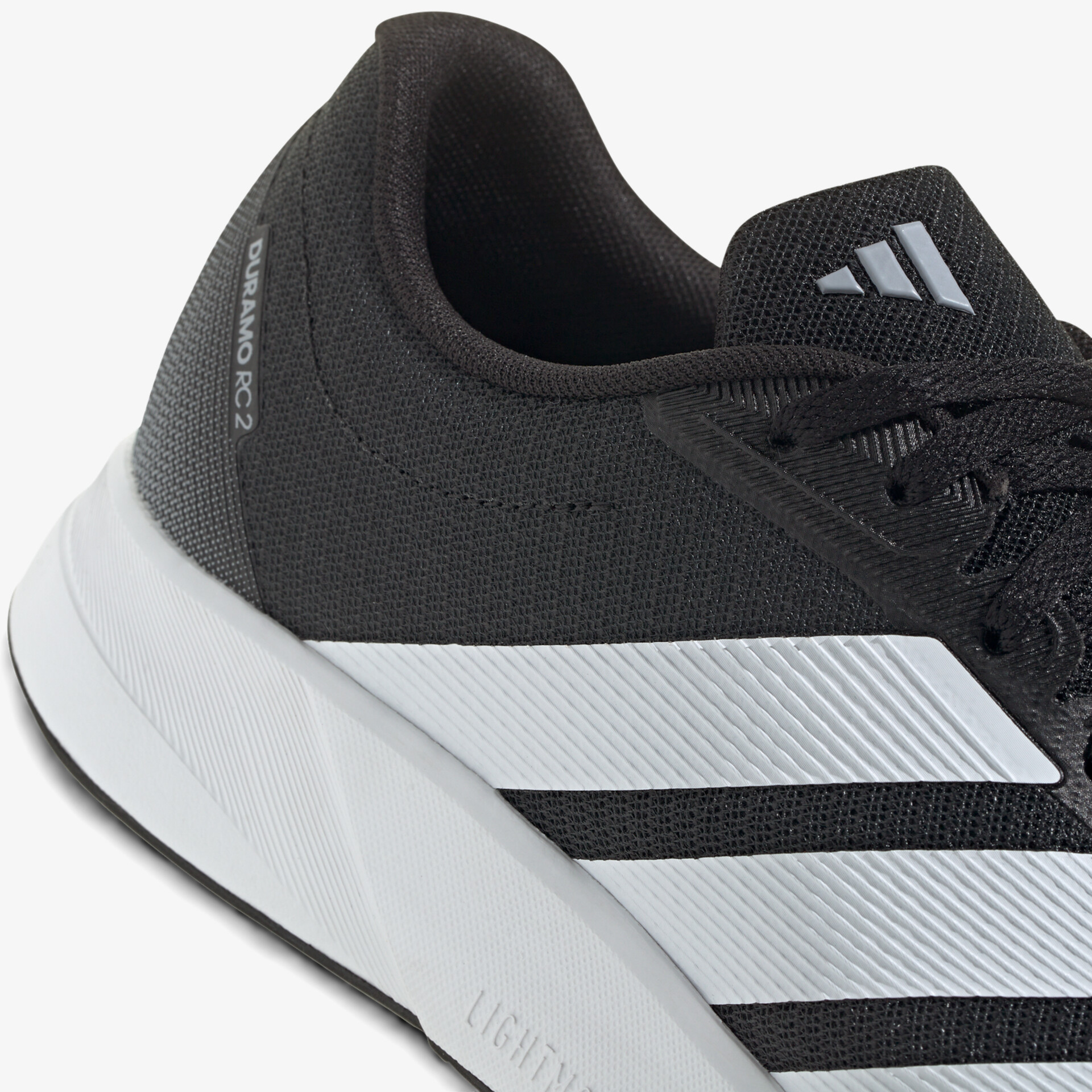 Schwarzer sportlicher Schuh mit atmungsaktivem Material und rutschfester weißer Sohle, klare Seitenansicht