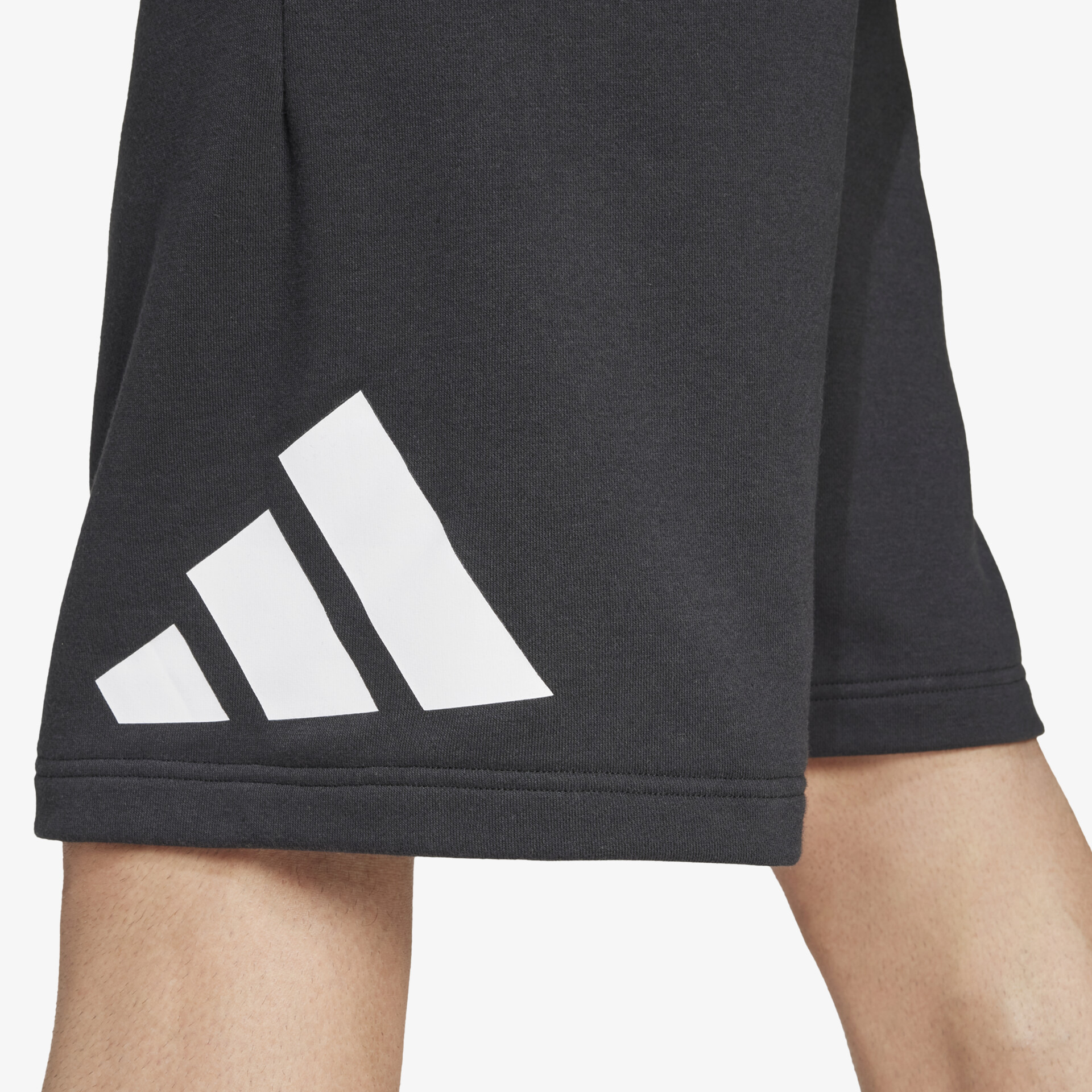 Detailaufnahme des weißen Adidas Logos auf schwarzem, elastischem und atmungsaktivem Shorts-Material