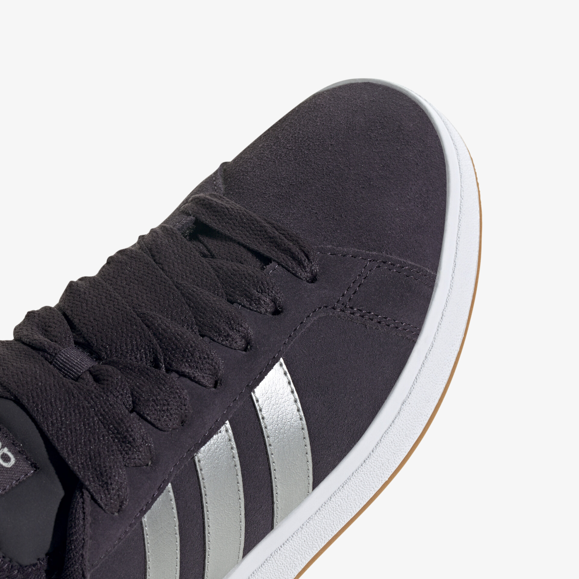 Detailaufnahme schwarzer Sneaker mit silbernen Streifen und robuster Schnürung für modernen Look