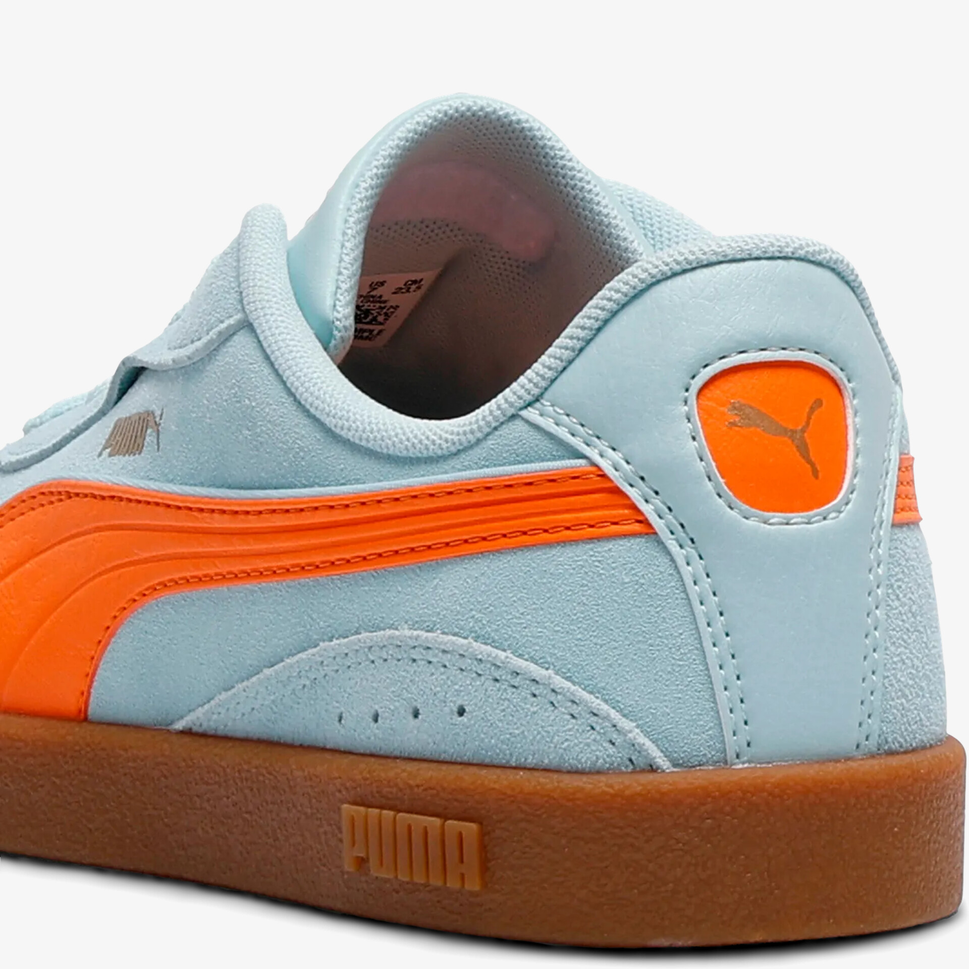 Hellblauer Schuh mit orangefarbener Logoverzierung und brauner kontrastreicher Sohle, seitliche Ansicht