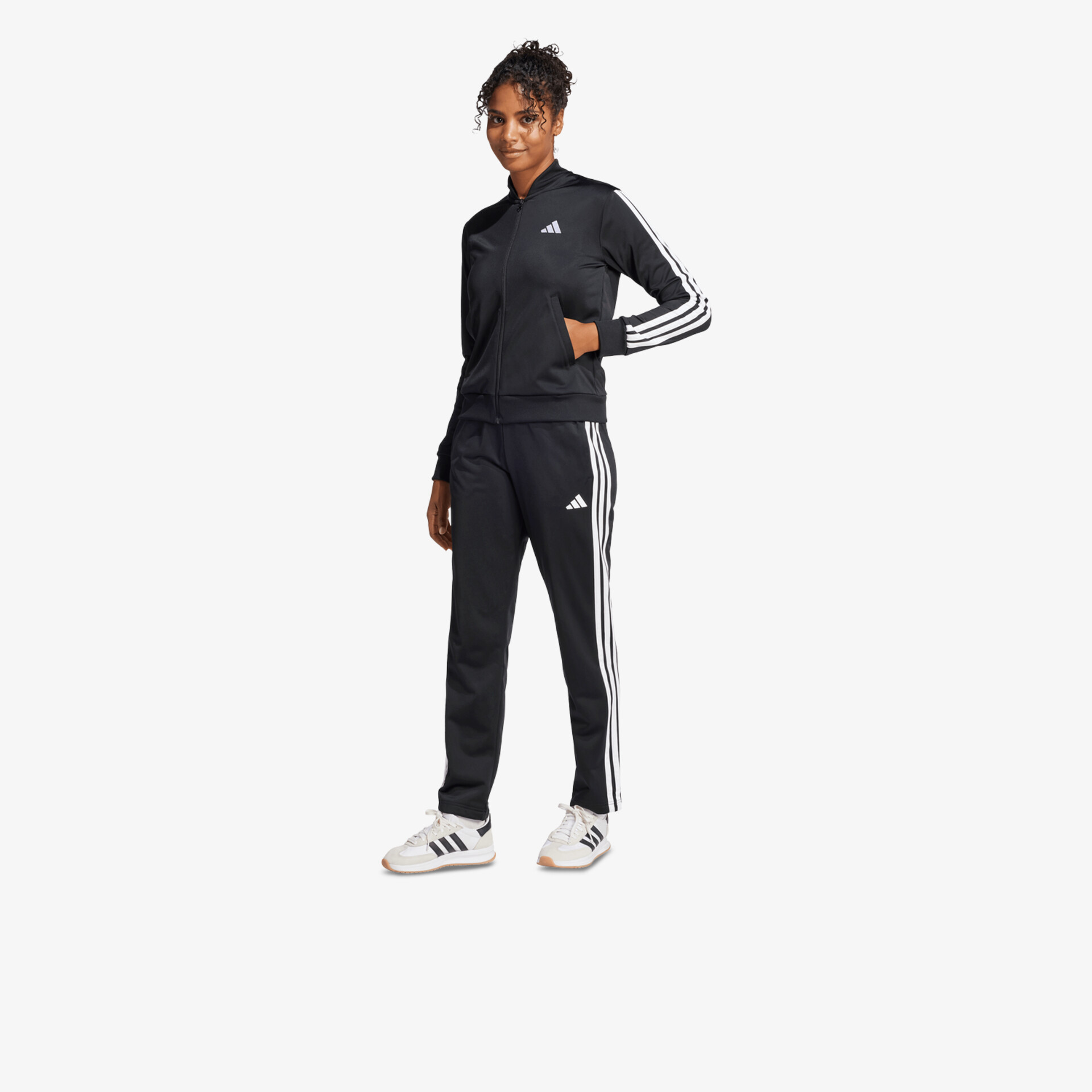 Modisches sportliches Trainingsshirt und Hose in entspannter Pose mit Drei-Streifen-Design