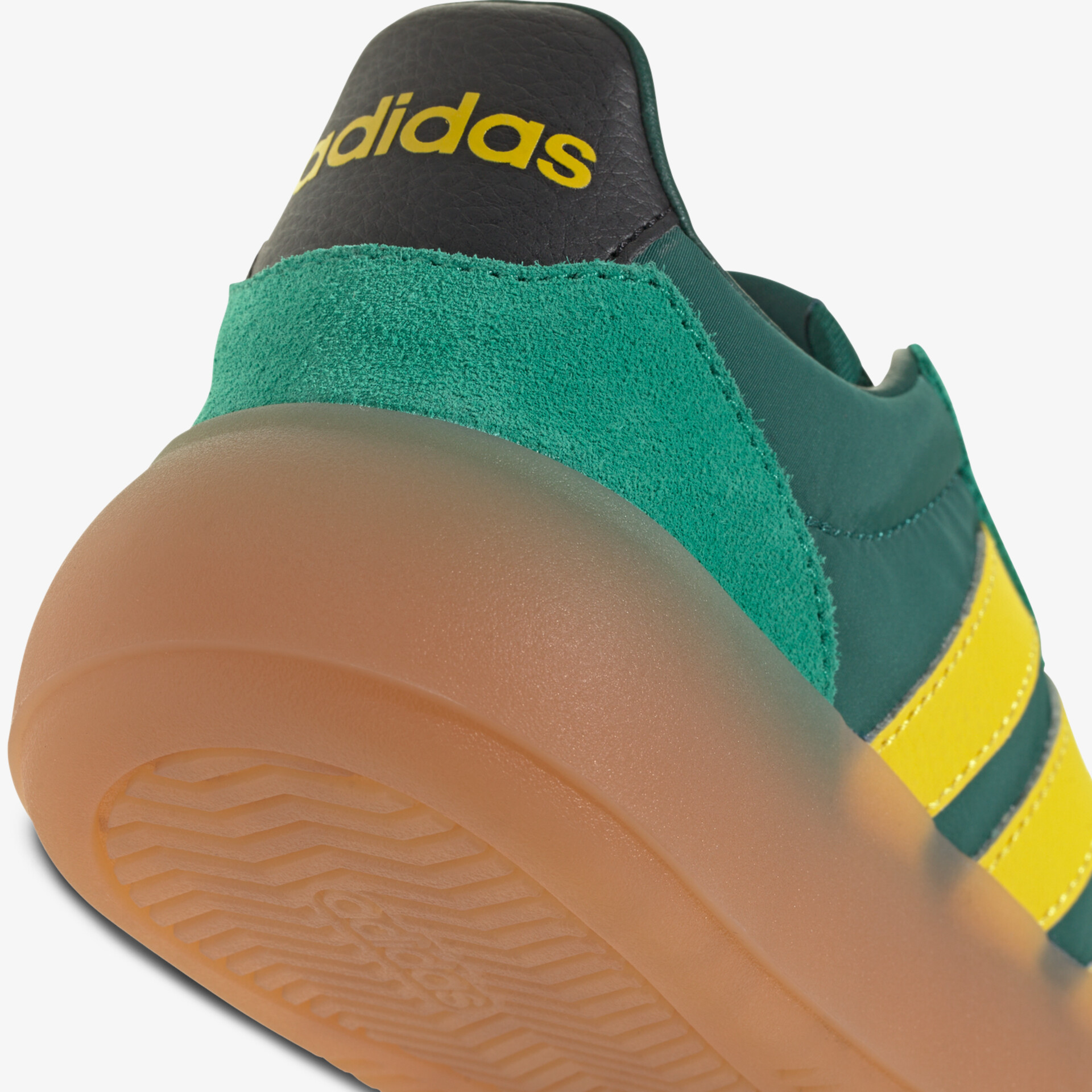 Grüner Adidas Sneaker mit gelben Streifen und robuster brauner Gummisohle in Detailansicht
