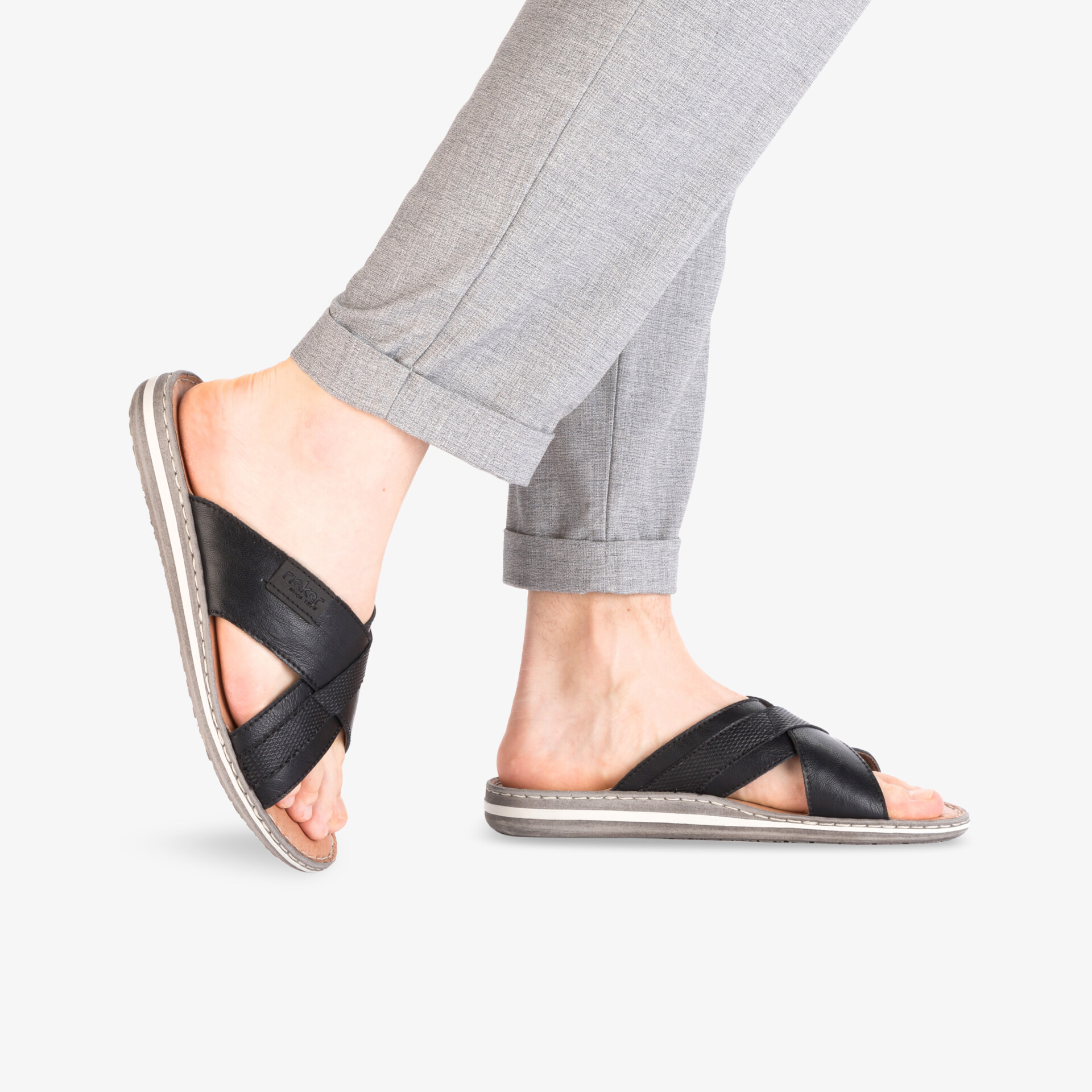 Bequeme schwarze Hausschuhe mit gekreuzten Riemen, leicht und atmungsaktiv, seitlich getragen am Fuß