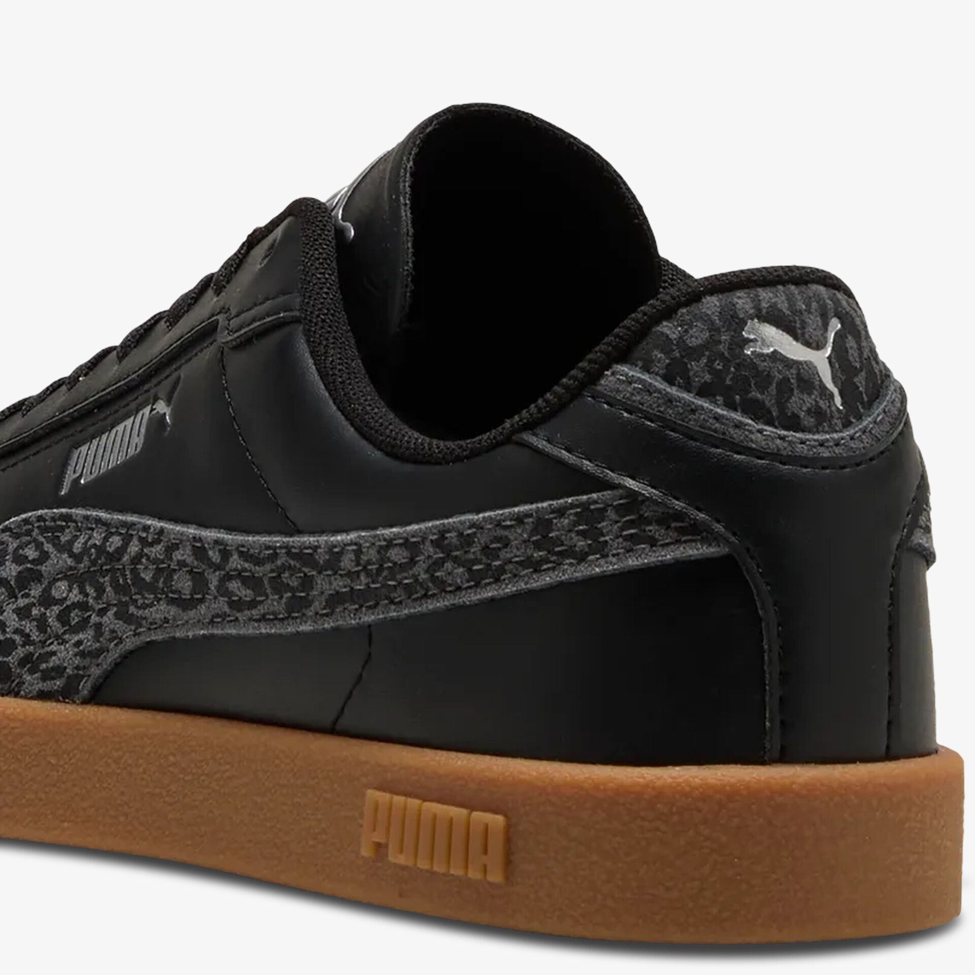 Schwarzer Puma Sneaker mit Wildlederdetails und robuster brauner Gummisohle in Rückansicht
