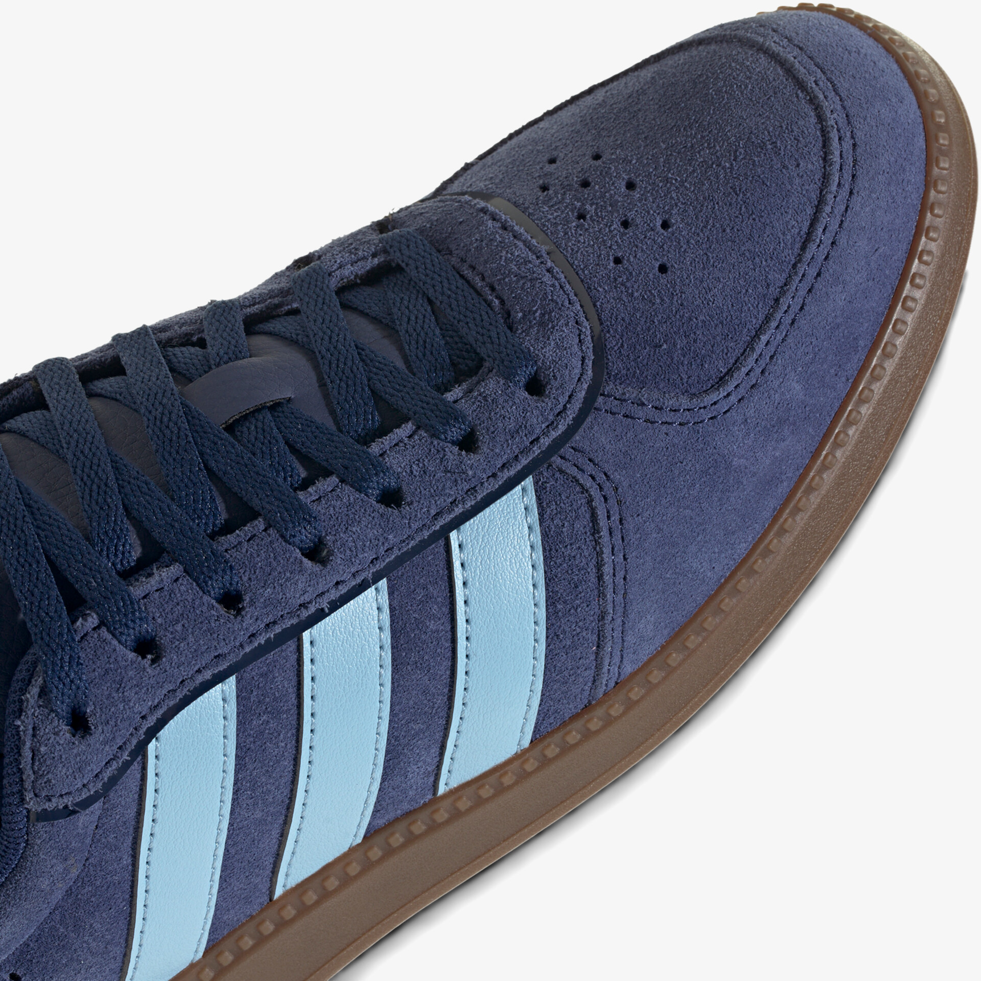 Dunkelblauer Wildleder-Sneaker mit hellblauen Zierstreifen und brauner Profilsohle, sportlich und bequem