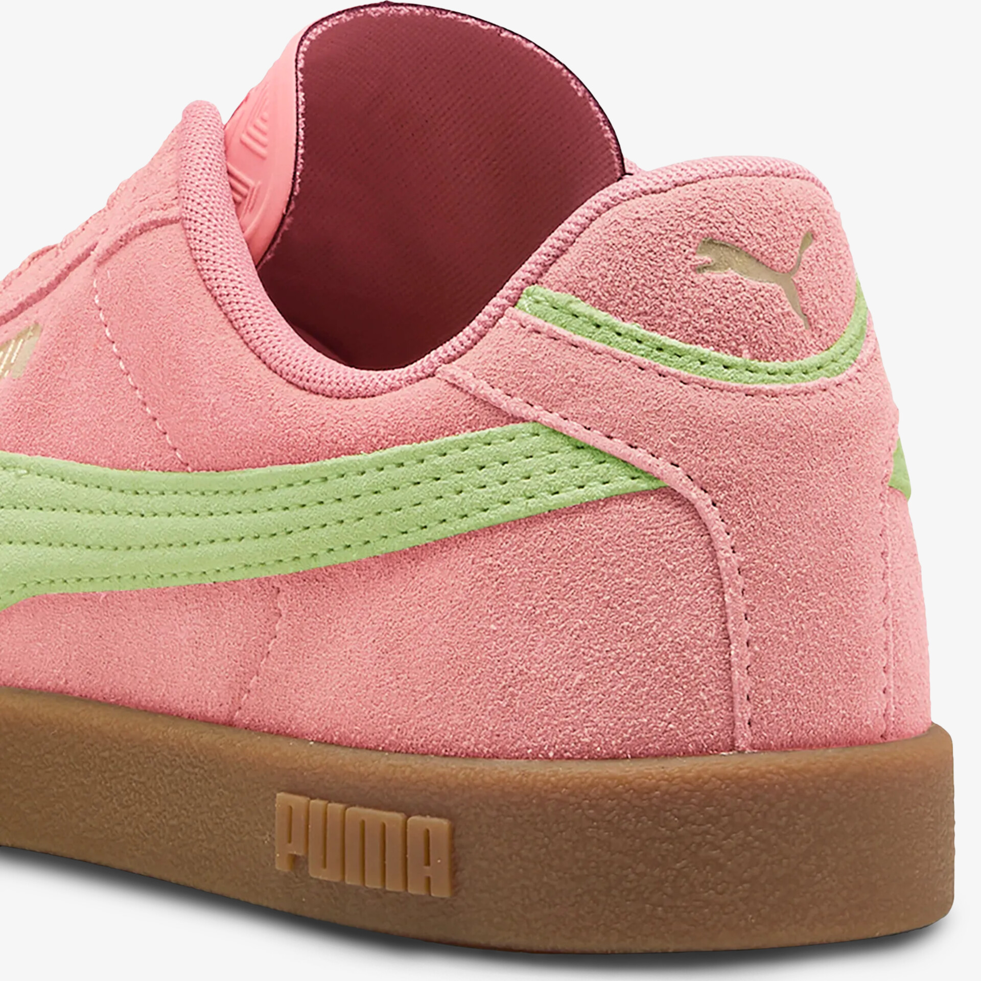 Detailaufnahme Sneaker aus rosafarbenem Veloursleder mit hellgrünem Puma-Streifen und brauner Gummisohle