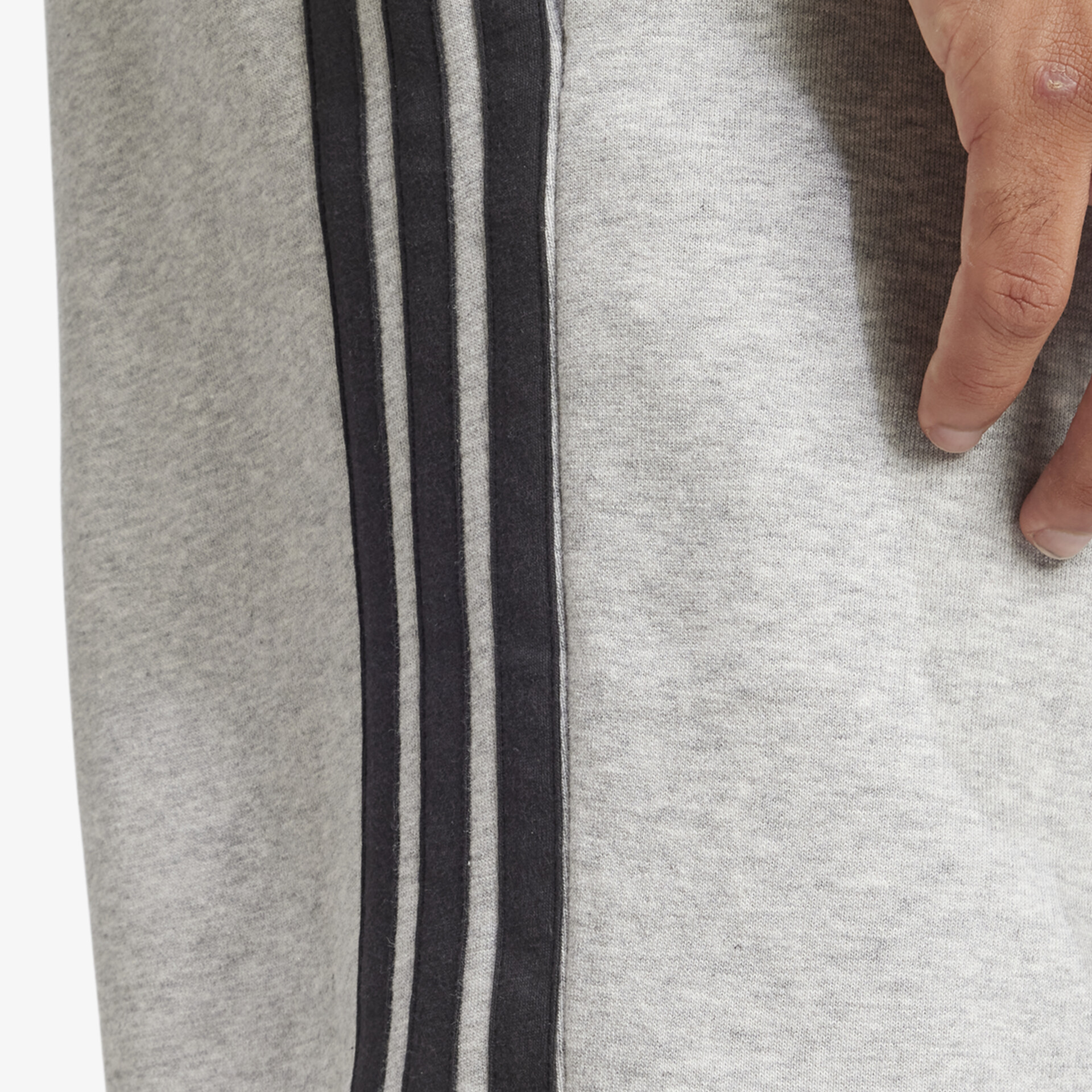 Detailaufnahme einer grauen Hose mit schwarzen Streifen, zeigt weiches, elastisches Material für hohen Tragekomfort