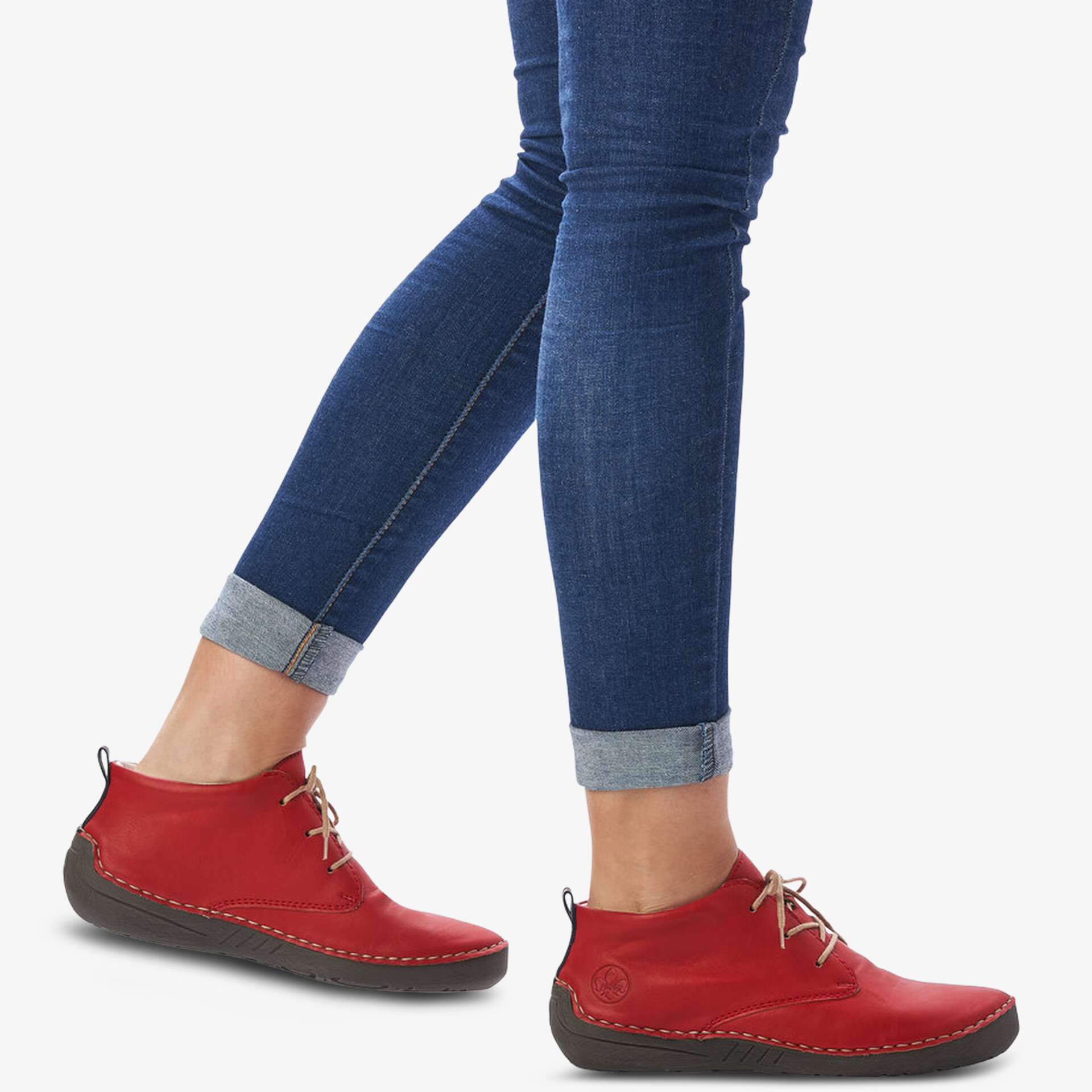 Rote Schnürschuhe mit flexibler Sohle und bequemer Passform, getragen an den Füßen in lässiger Jeans