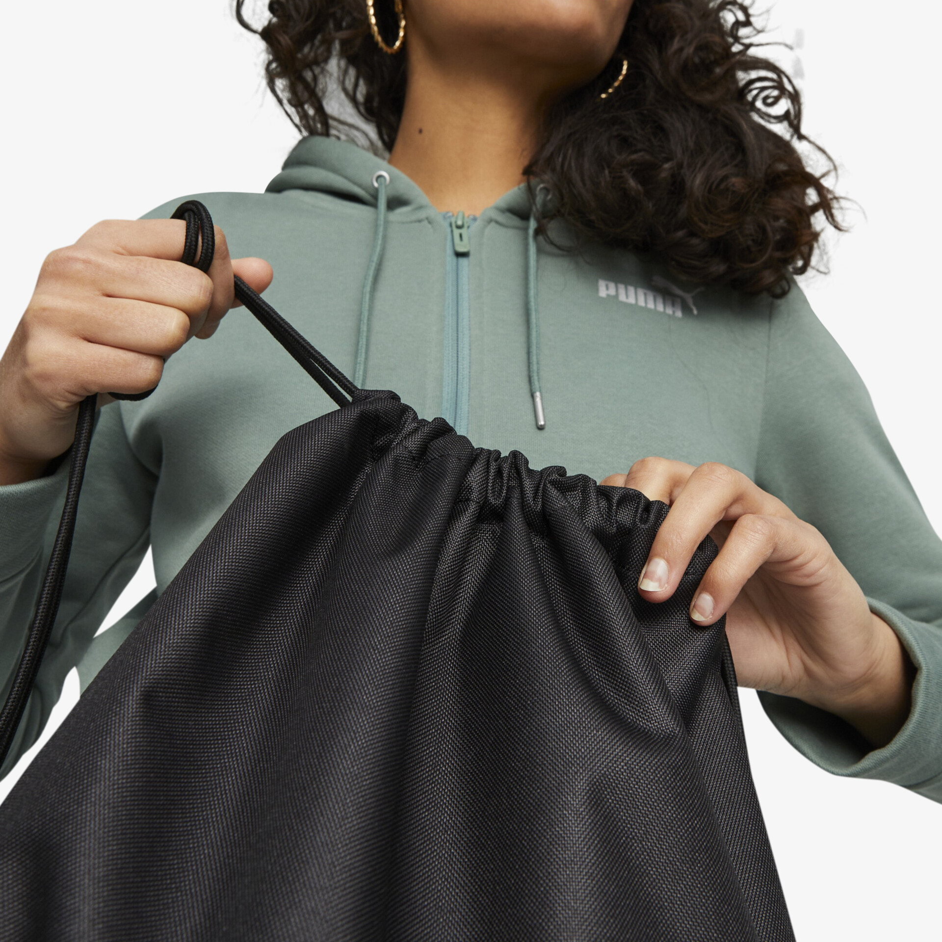 Hand zieht robusten Zugband-Beutel praktisch und einfach zu schließen, detailreiche Nahaufnahme