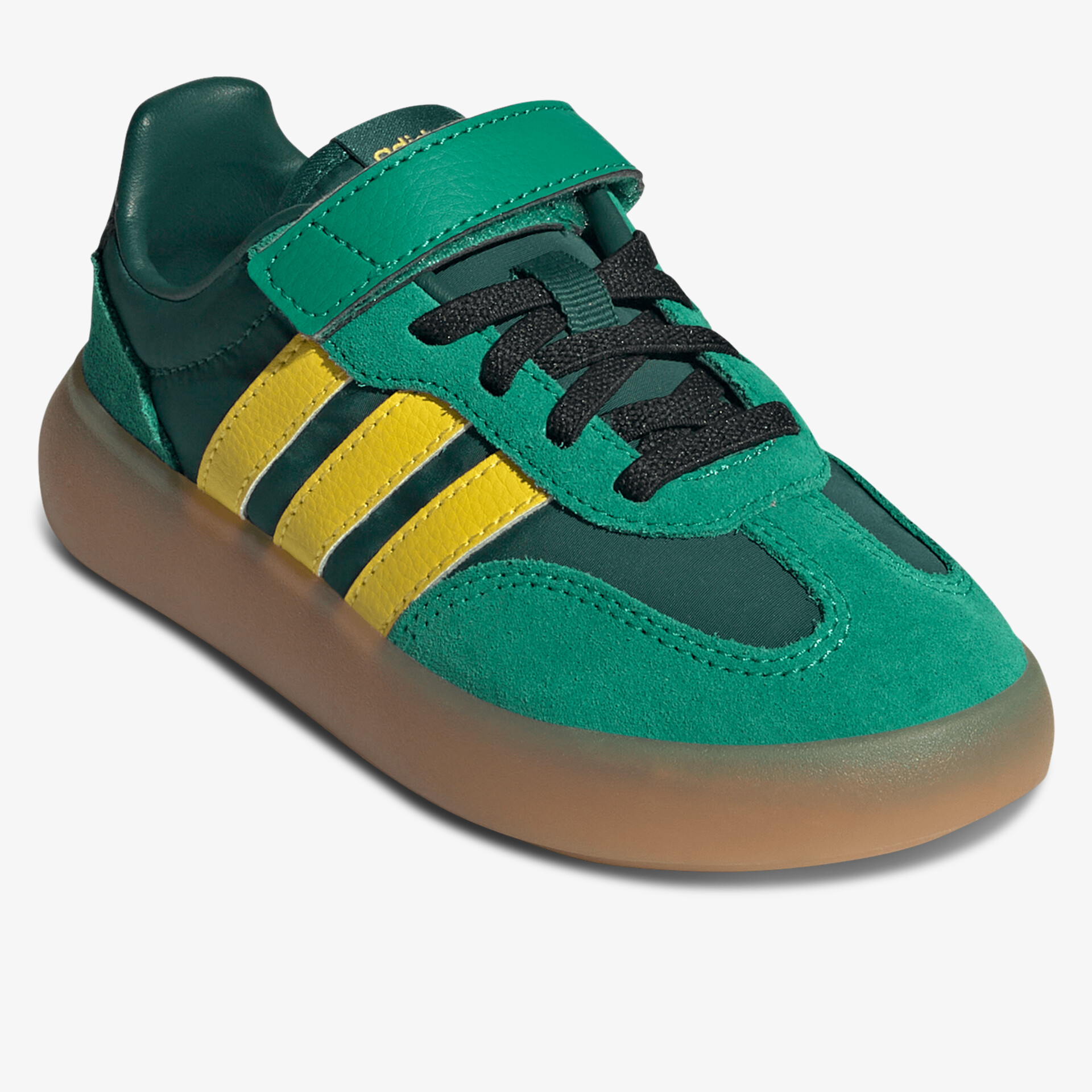 Grüner sportlicher Schuh mit gelben Streifen und Klettverschluss, rutschfeste braune Sohle, seitliche Ansicht