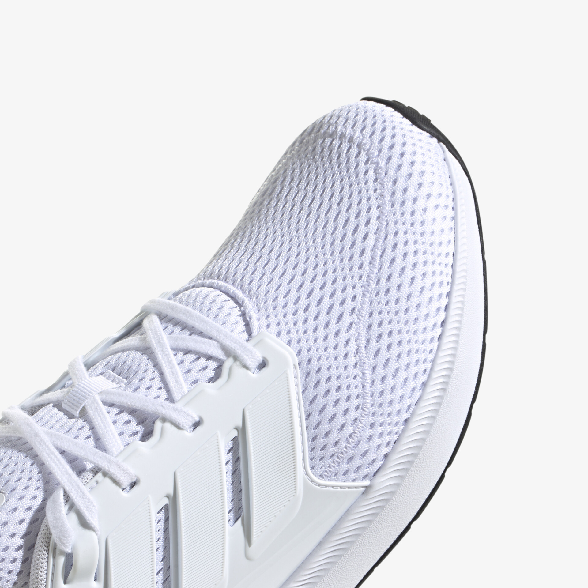 Detailaufnahme eines weißen Sportschuhs mit atmungsaktivem Material und flexibler Schnürung