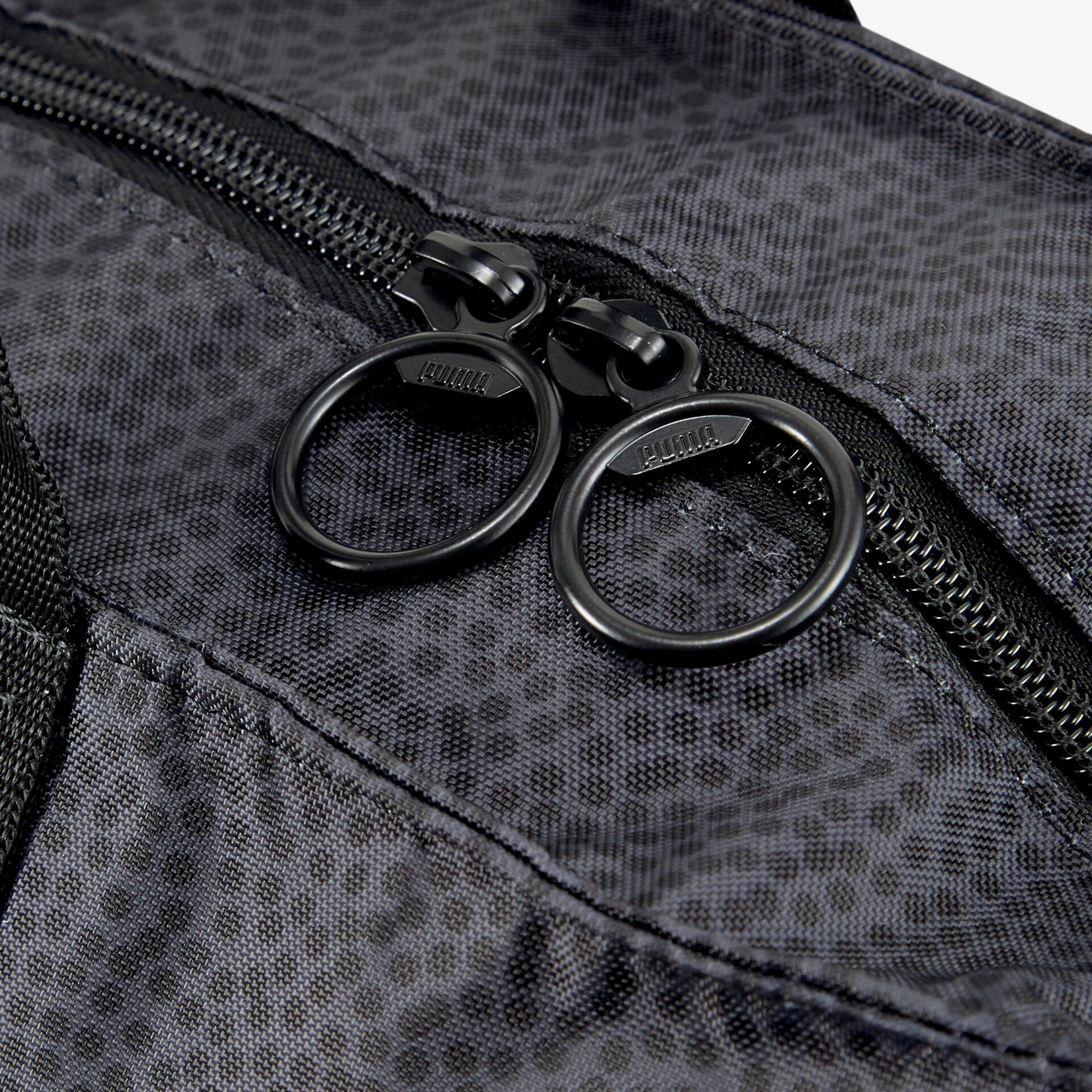 Schwarzer Reißverschluss mit robusten Metallringen nah am Stoffdetail, ideal für Taschen und Rucksäcke.