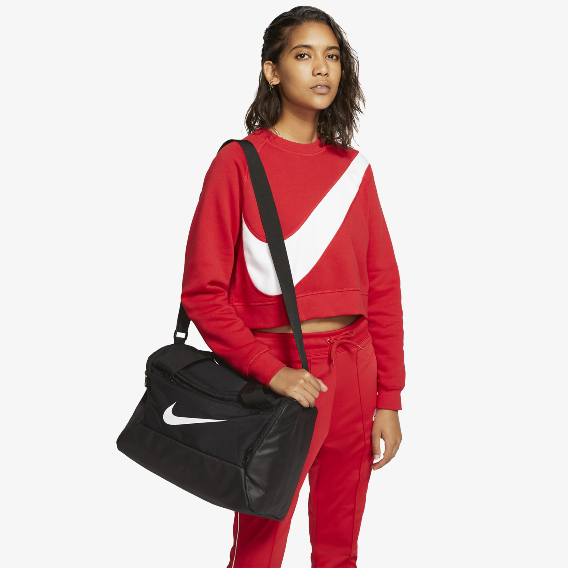 Sportlich-rotes Outfit mit markantem Nike-Logo und passender schwarzer Tasche