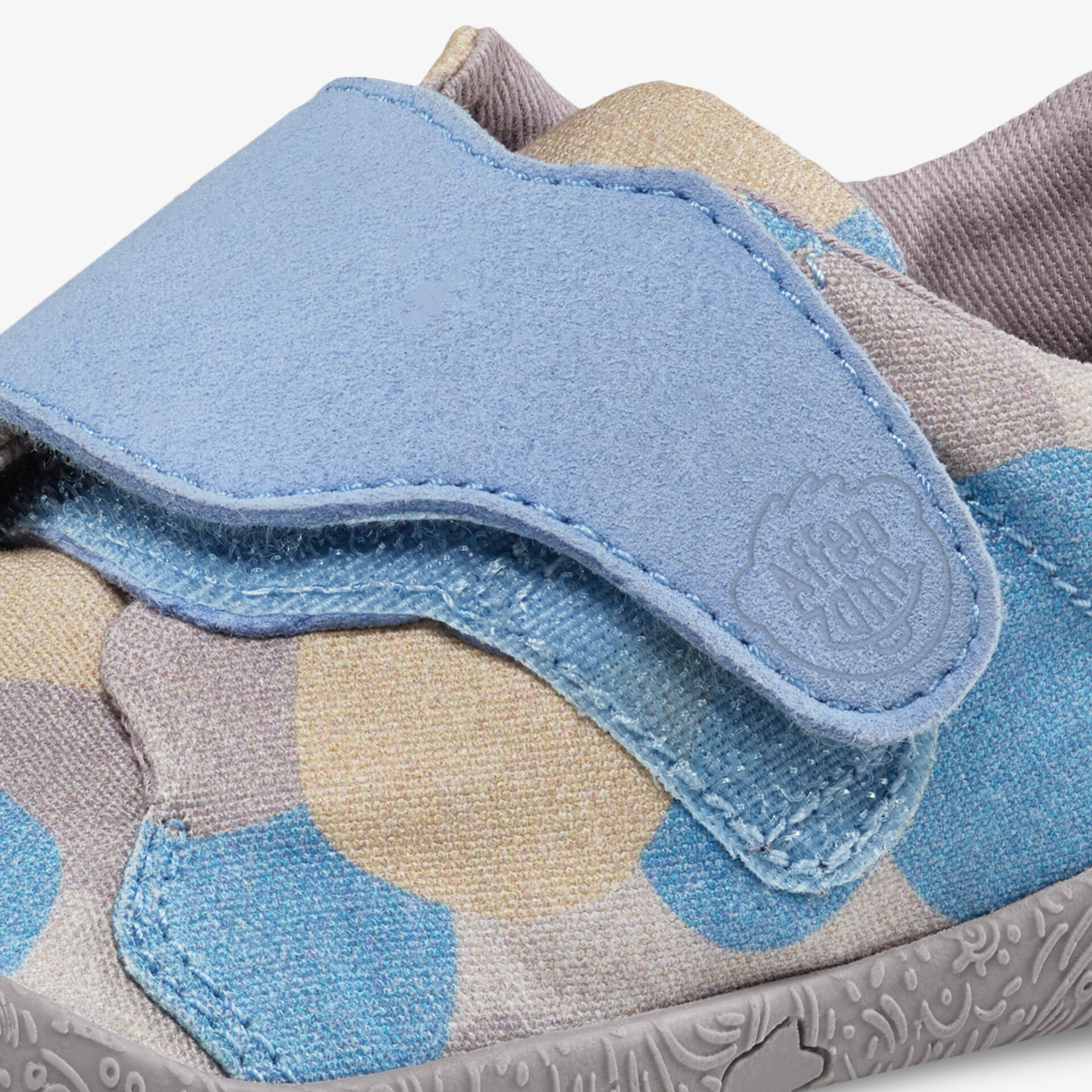 Detailaufnahme eines blau-beige gemusterten Schuhs mit praktischem Klettverschluss und weichem Textilmaterial