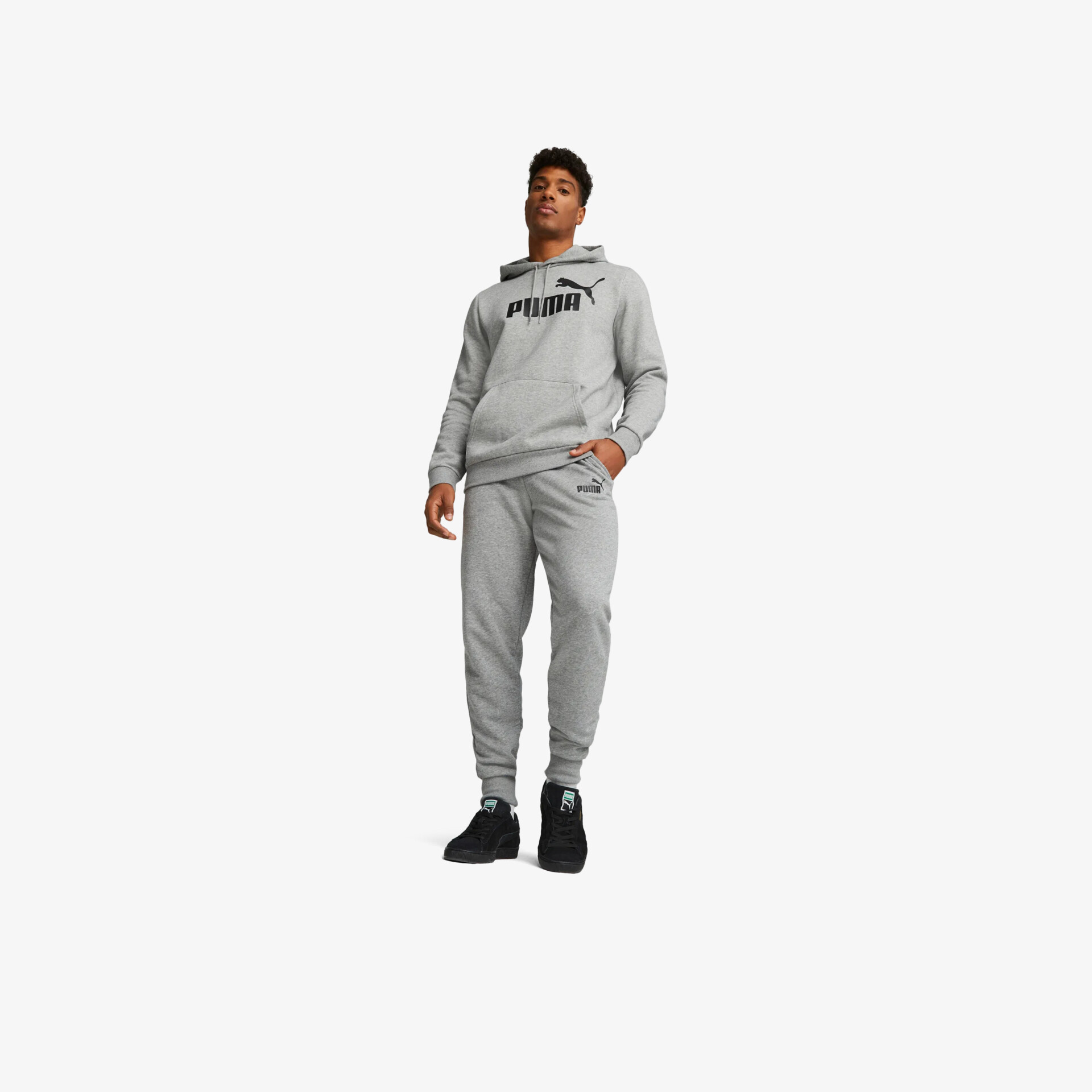 Person trägt grauen Jogginganzug mit Kapuze und schwarzen Sportschuhen, sportlicher und bequemer Look