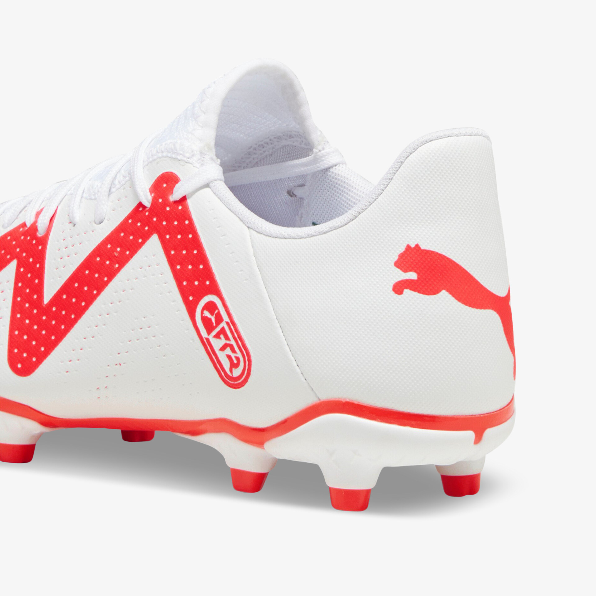 Weiße Fußballschuhe mit roten Akzenten, optimaler Grip und Stabilität auf dem Spielfeld.