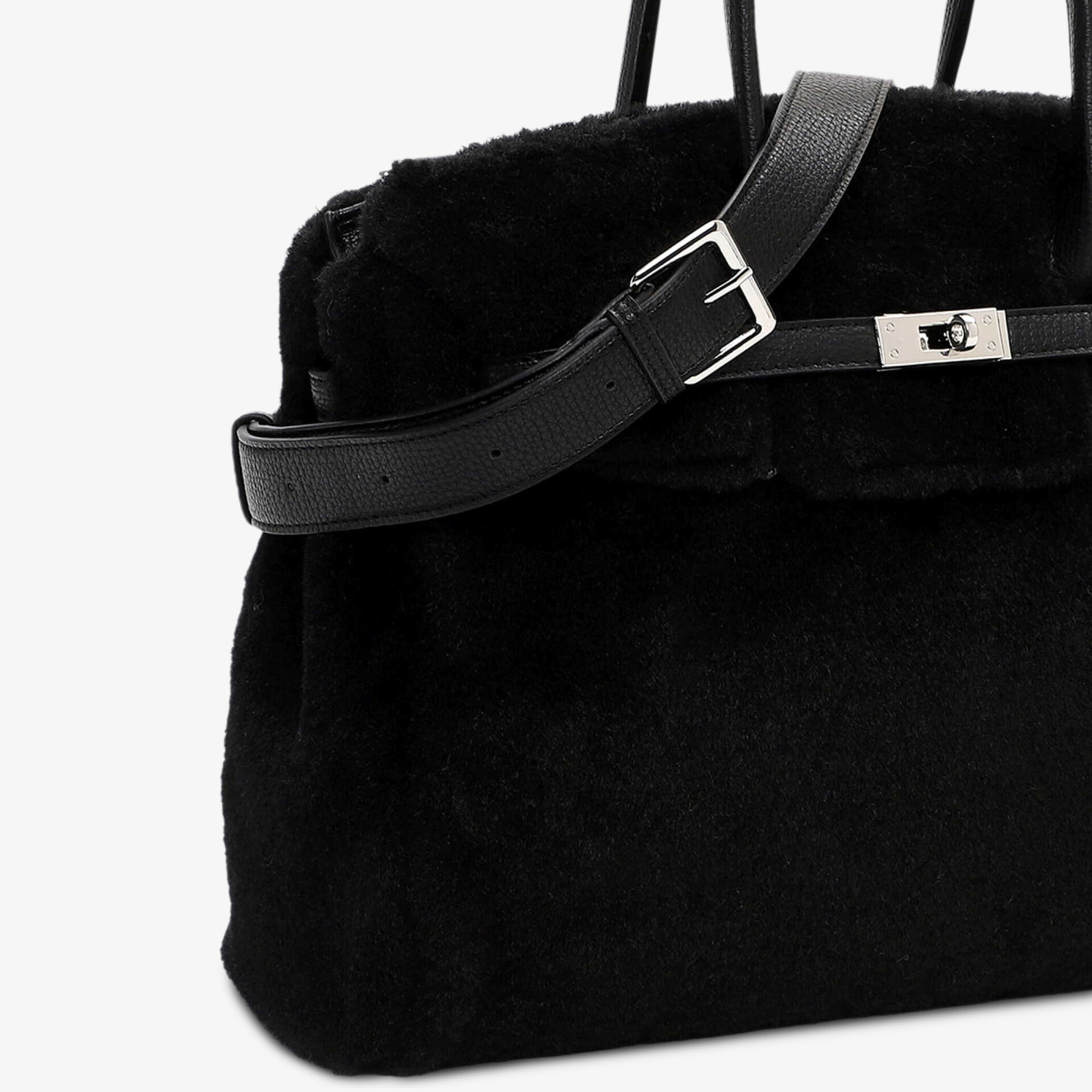 Schwarze Tasche aus weichem Fellmaterial mit verstellbarem Riemen und elegantem Metallverschluss Detailaufnahme
