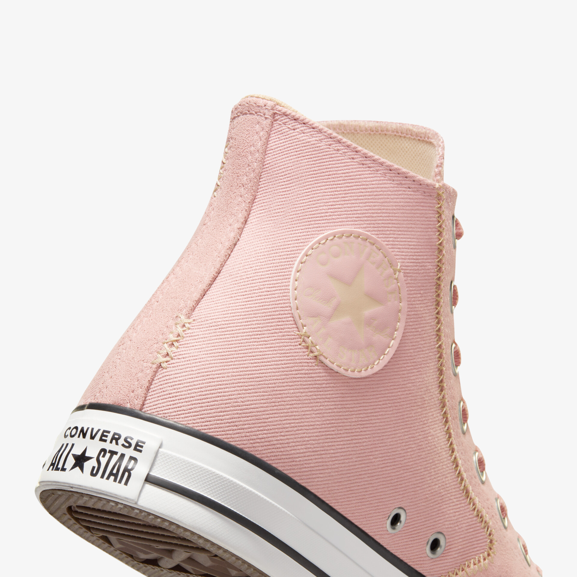 Detailaufnahme eines robusten, hohen Sneakers mit klassischer Schnürung und markantem Logo in Rosaton