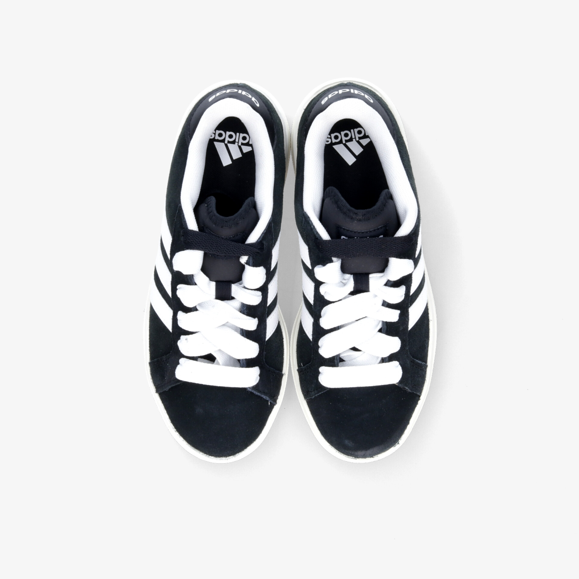 Bequeme schwarze und weiße Sneaker mit schnürsenkeln im Top-Down Blickwinkel, sportlich und strapazierfähig