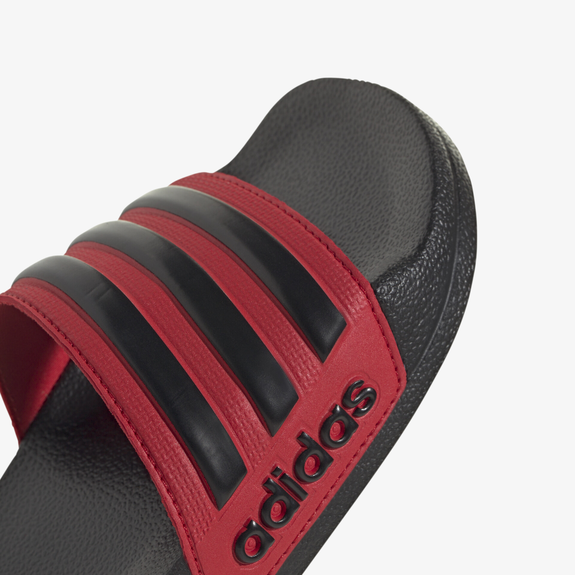 Detailaufnahme eines rot-schwarzen Adidas Riemensandschuhs mit bequemem Design und strapazierfähigem Material